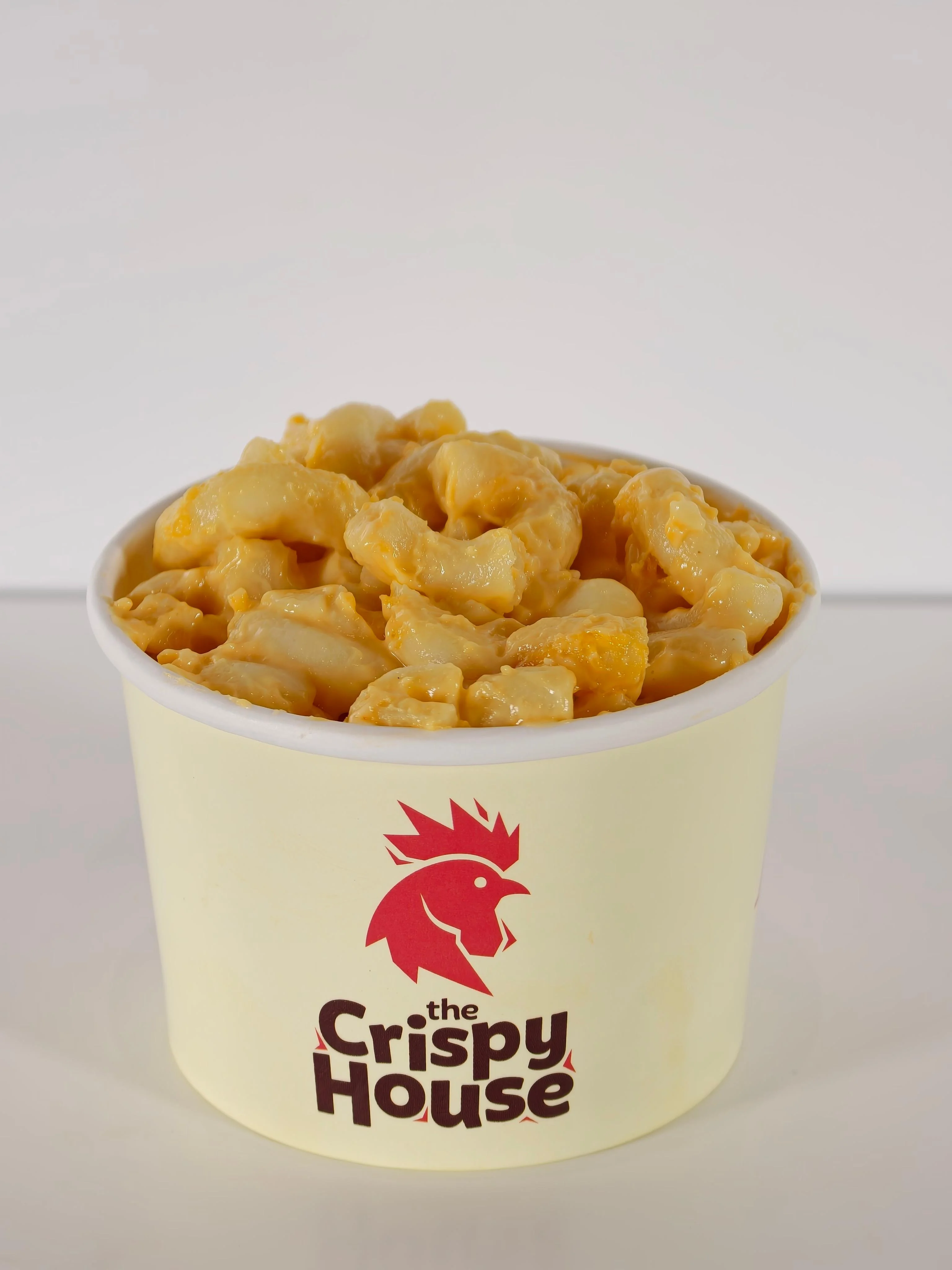 A cup filled with creamy macaroni and cheese, featuring a rich orange color.