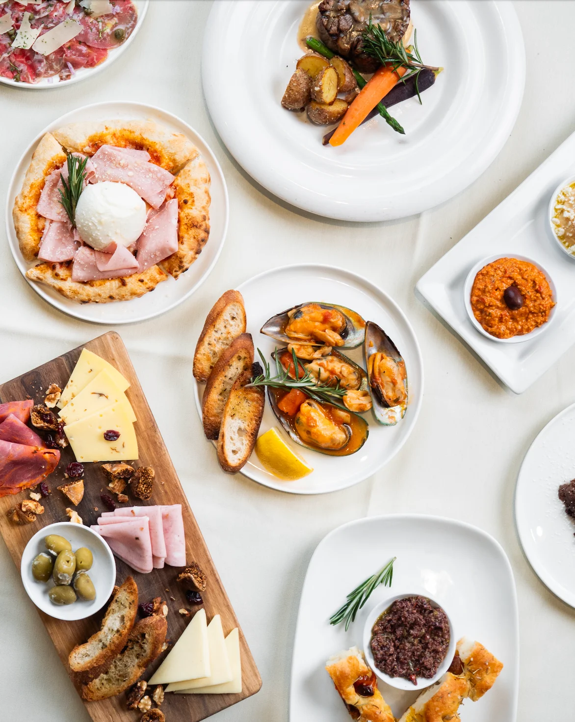 A variety of gourmet dishes including meats, seafood, and cheeses.