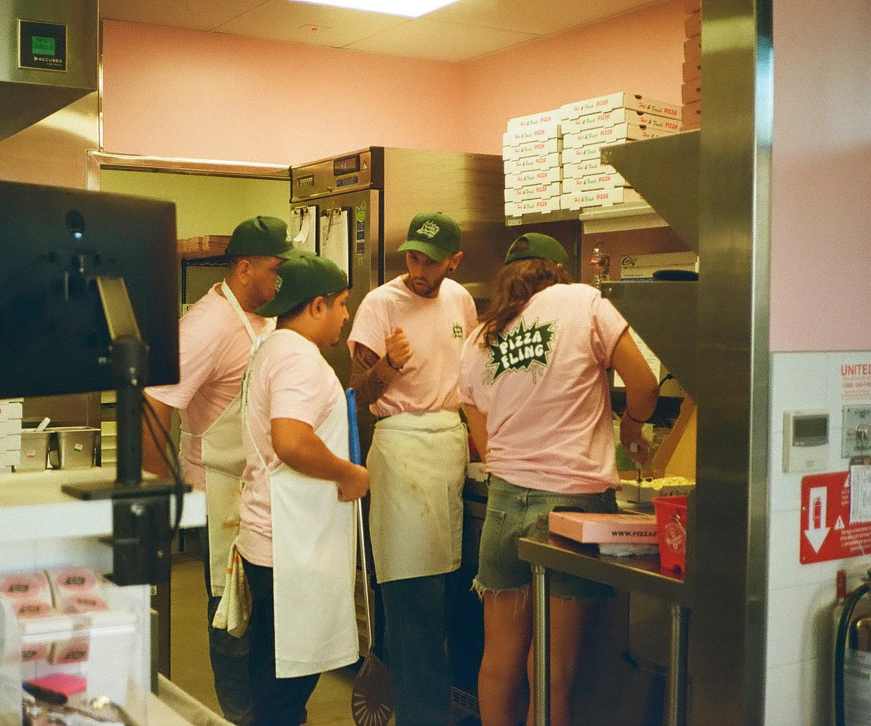 Pizza kitchen staff preparing fresh pies in a vibrant setting