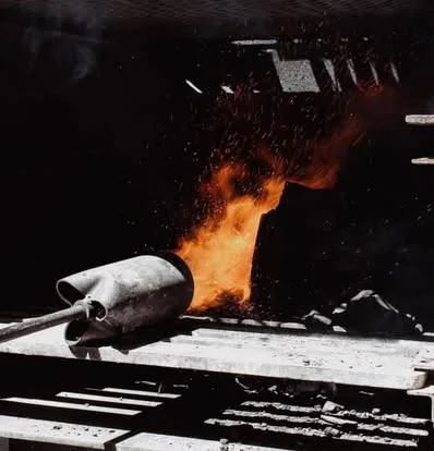 Molten metal being poured from a crucible in a foundry