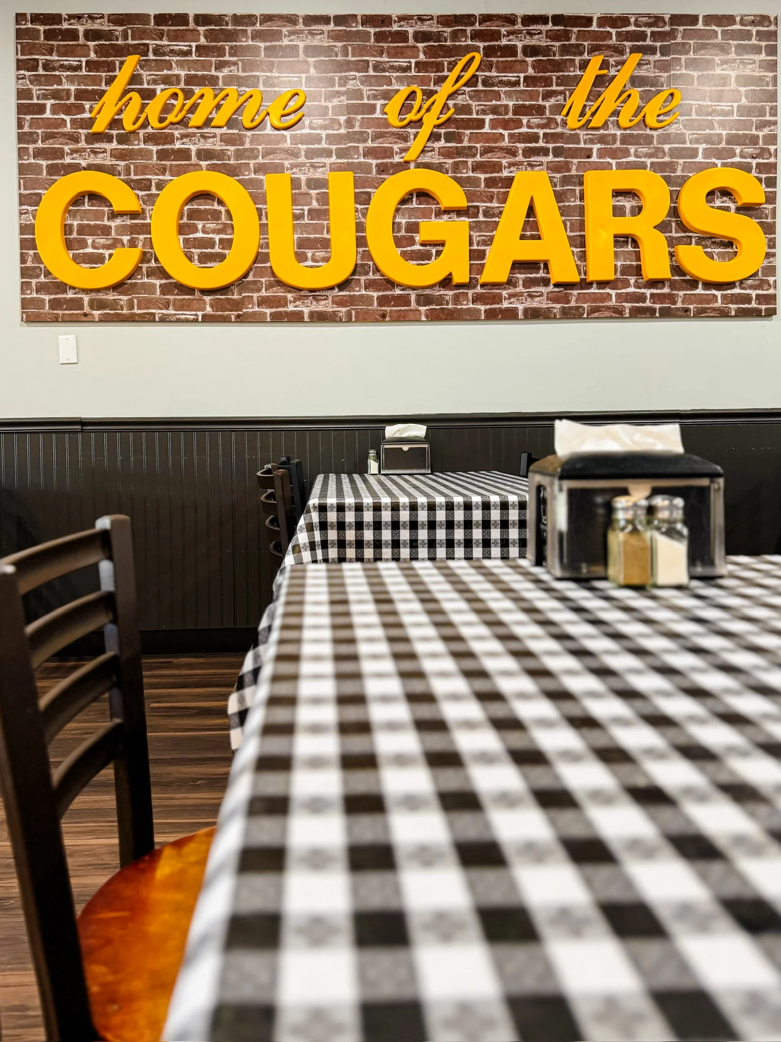 Cozy restaurant interior with brick wall and checkered tablecloths