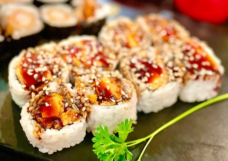 Japanese sushi rolls with eel sauce and sesame seeds
