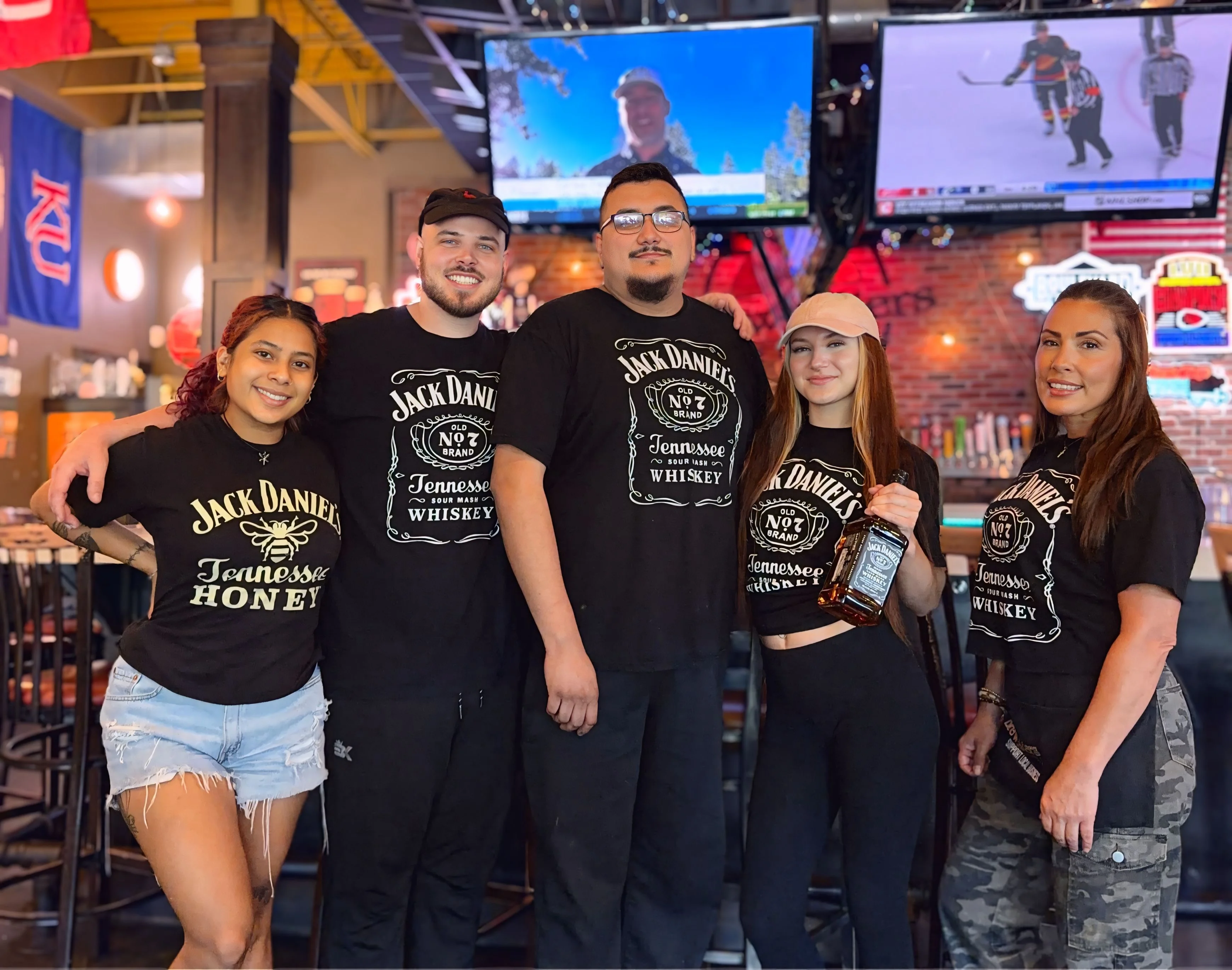 Staff posing in a lively bar with Jack Daniel's branding