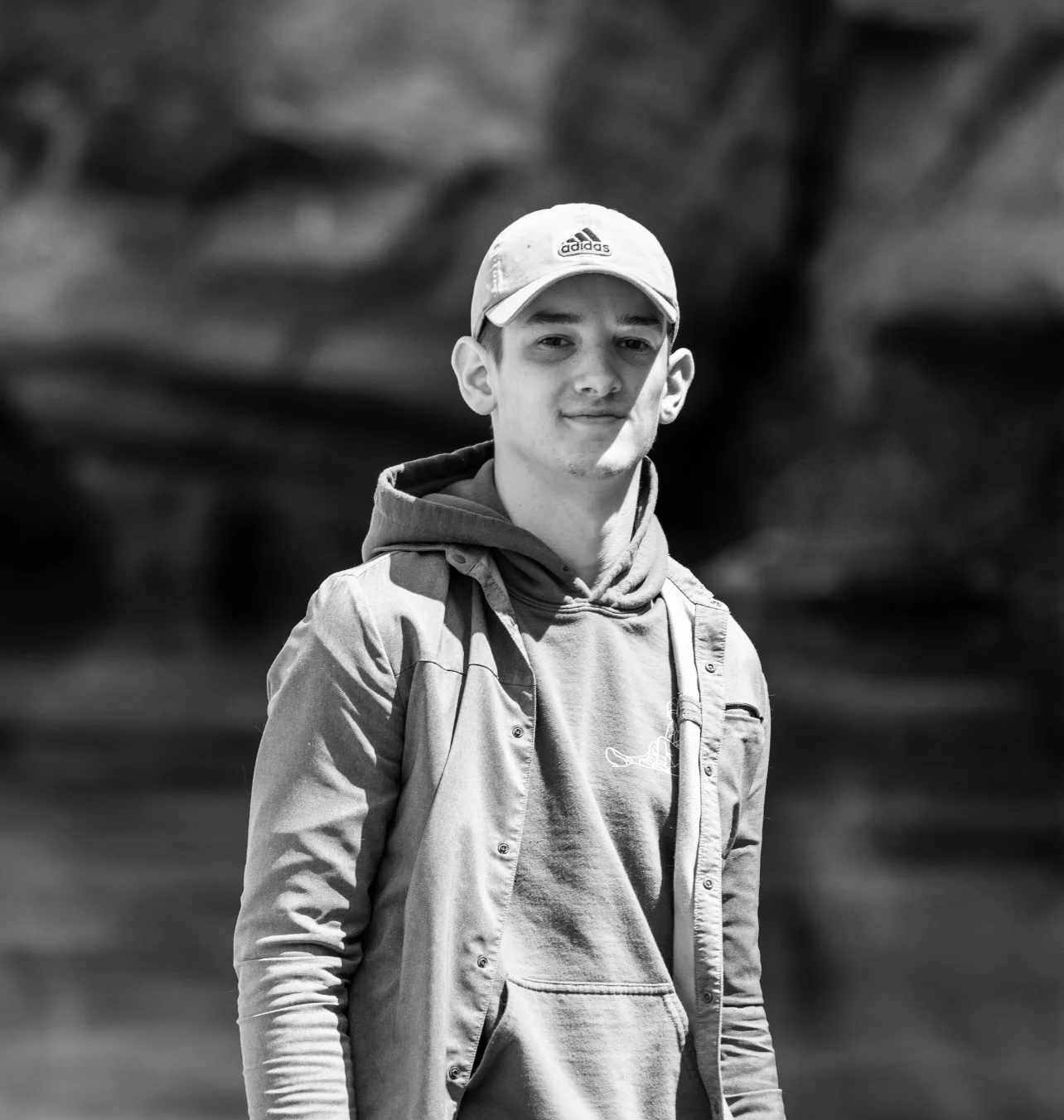 Young man standing on a beach in black and white