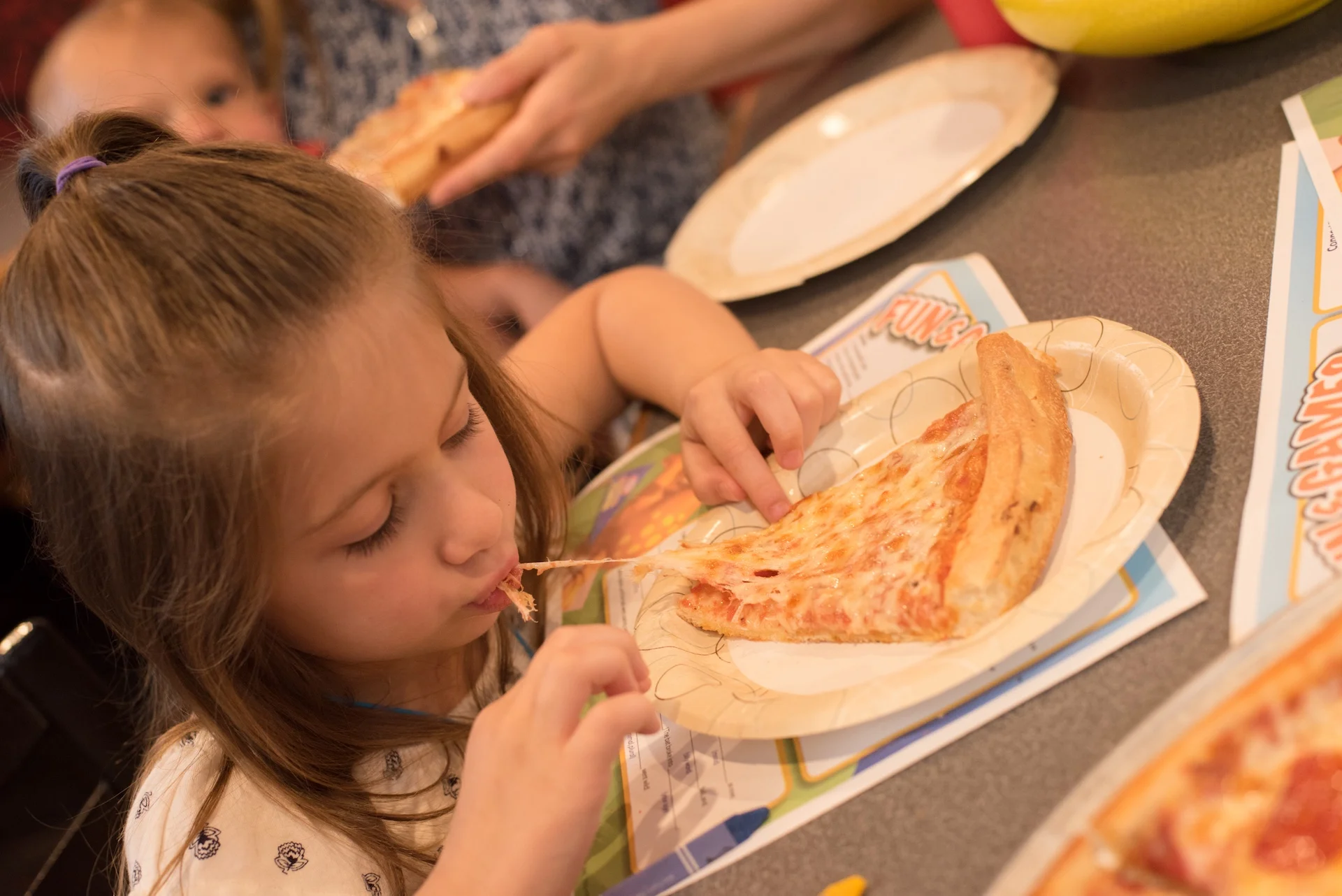 Child enjoying a slice of classic cheese pizza