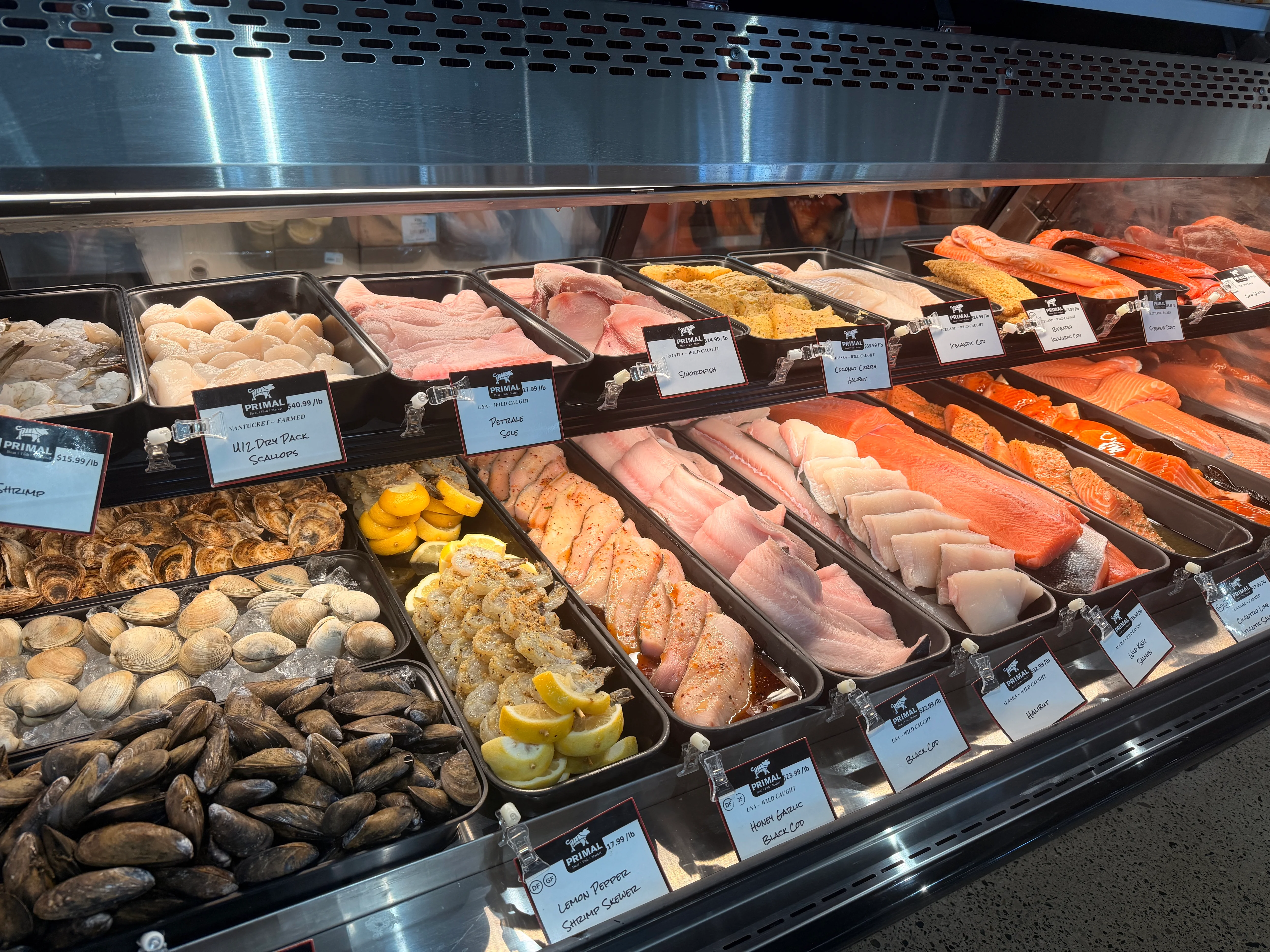 Fresh seafood market display with salmon, shellfish, oysters, clams, and shrimp