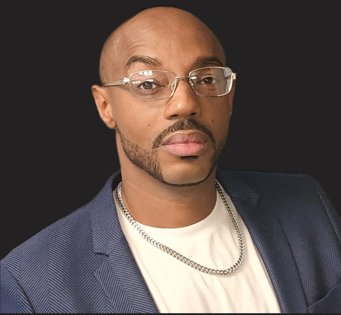 Professional portrait of a man in a blazer with glasses