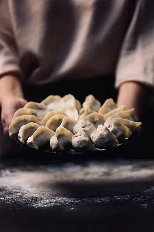 Plate of handmade Chinese dumplings ready for cooking