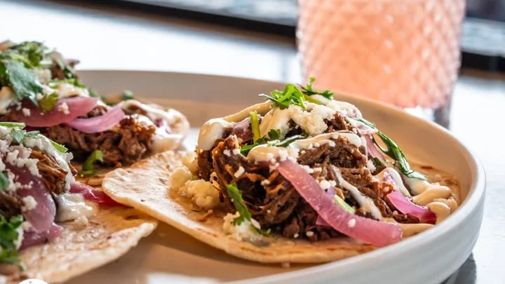 Colorful Mexican tacos and seafood tostadas with a cocktail