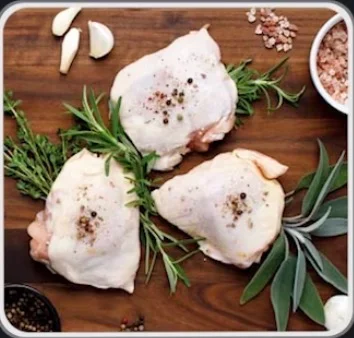 Raw chicken thighs with herbs and spices on a wooden board