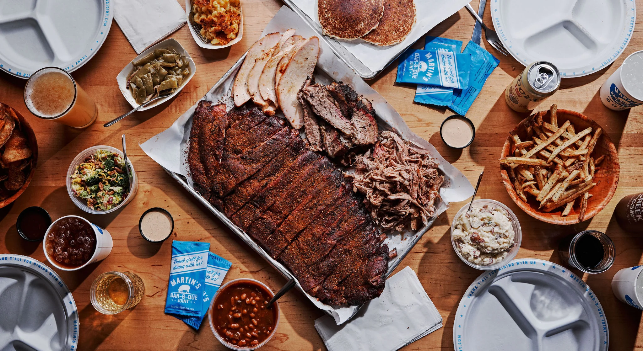 A spread of BBQ with a graphic titled "Red, White & 'Que" with a rocket and pig. A side banner states to "Place Your Order Today!".
