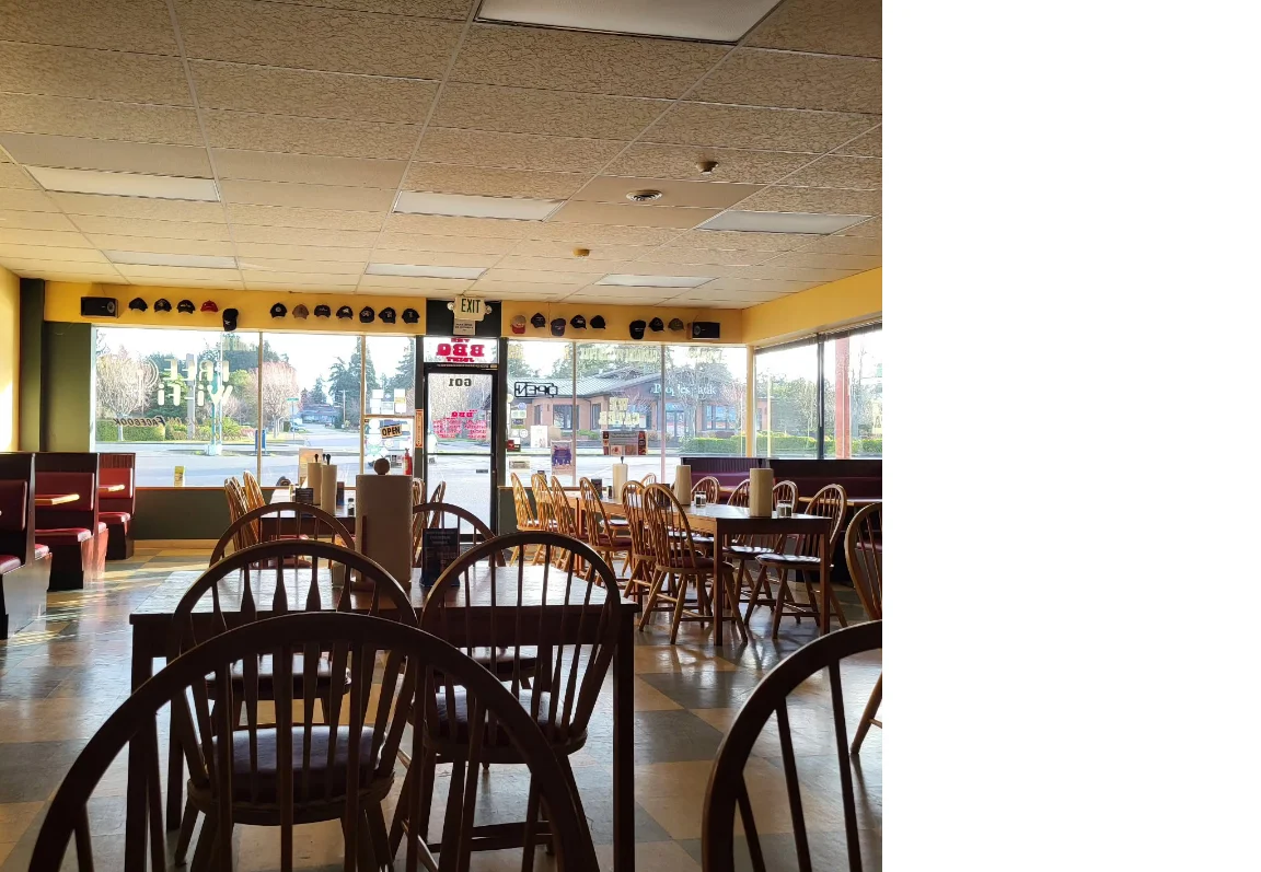 Cozy restaurant interior with wooden chairs and large windows