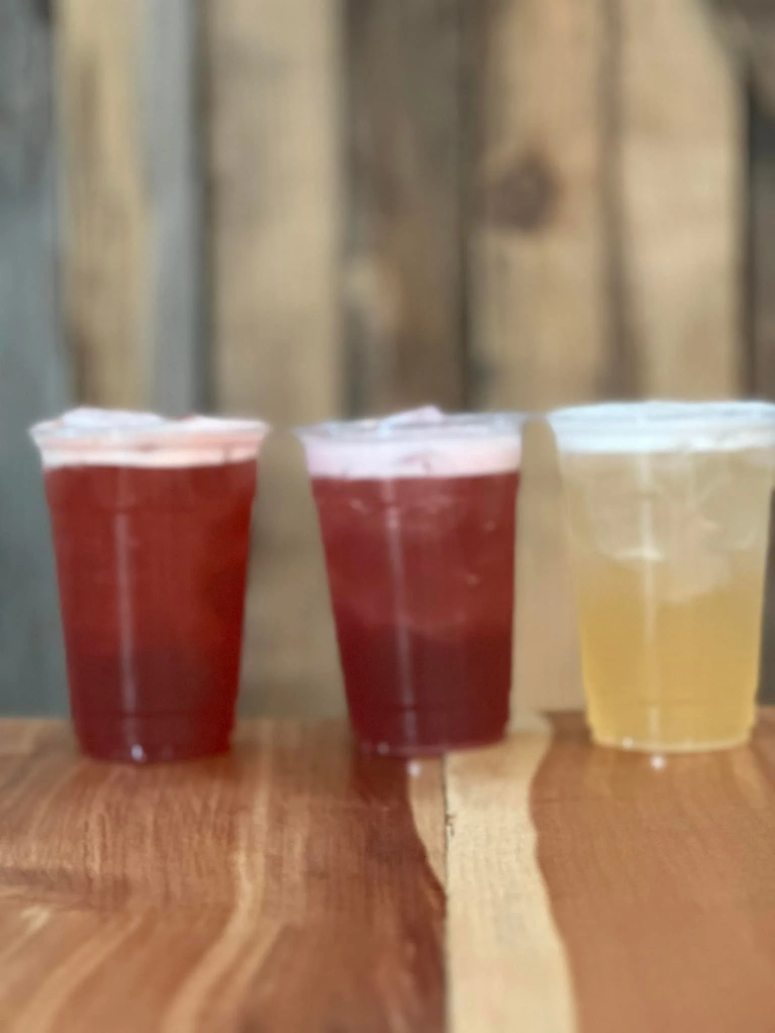 Refreshing beverages in clear cups on a wooden table