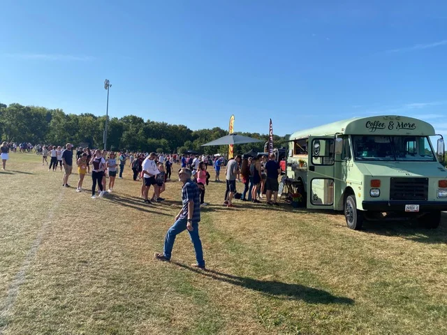 Crowd enjoying food truck offerings at a sunny outdoor event