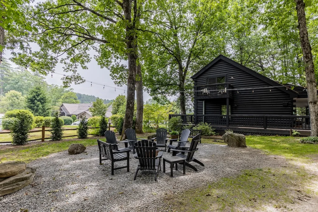 Outdoor seating area with fire pit surrounded by trees