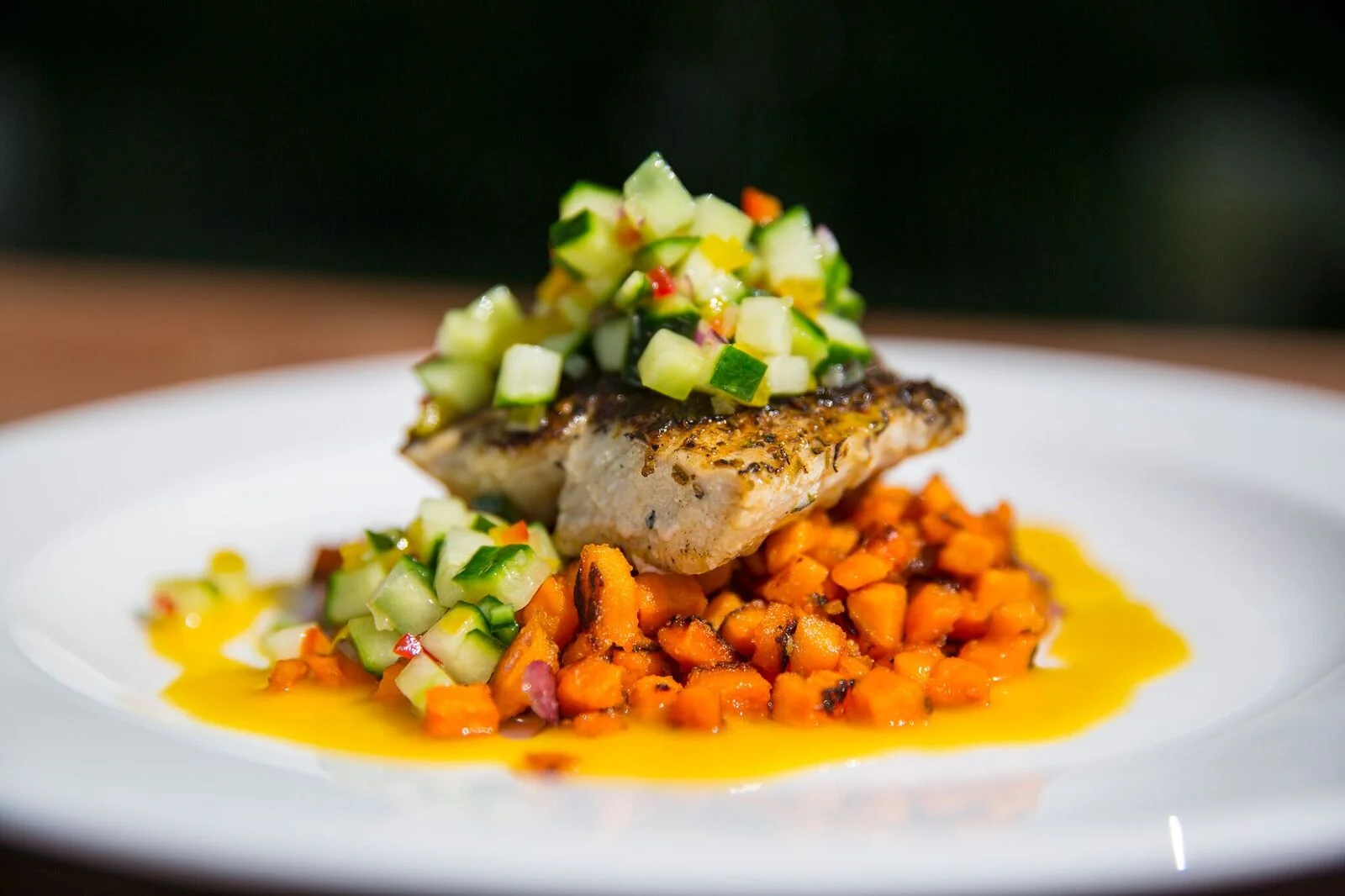 Grilled fish with cucumber salsa on a bed of sweet potatoes