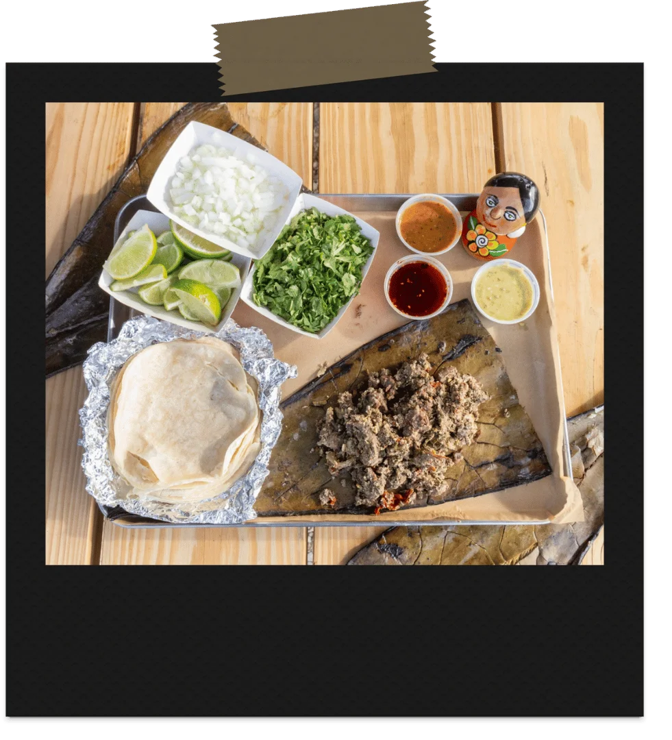 Authentic Mexican tacos with various toppings and salsas on a wooden table