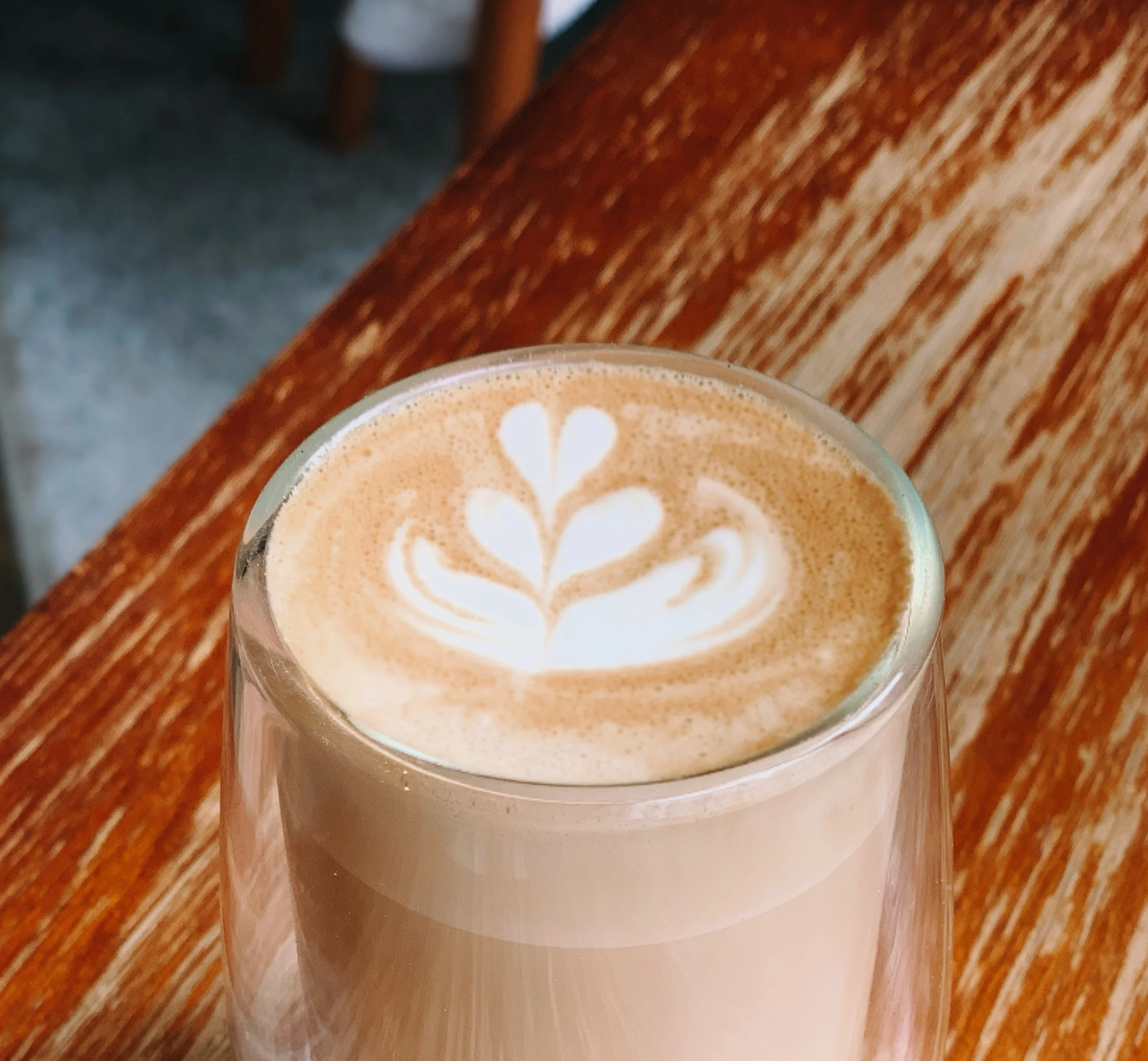 Artisan latte with beautiful foam art in a glass cup