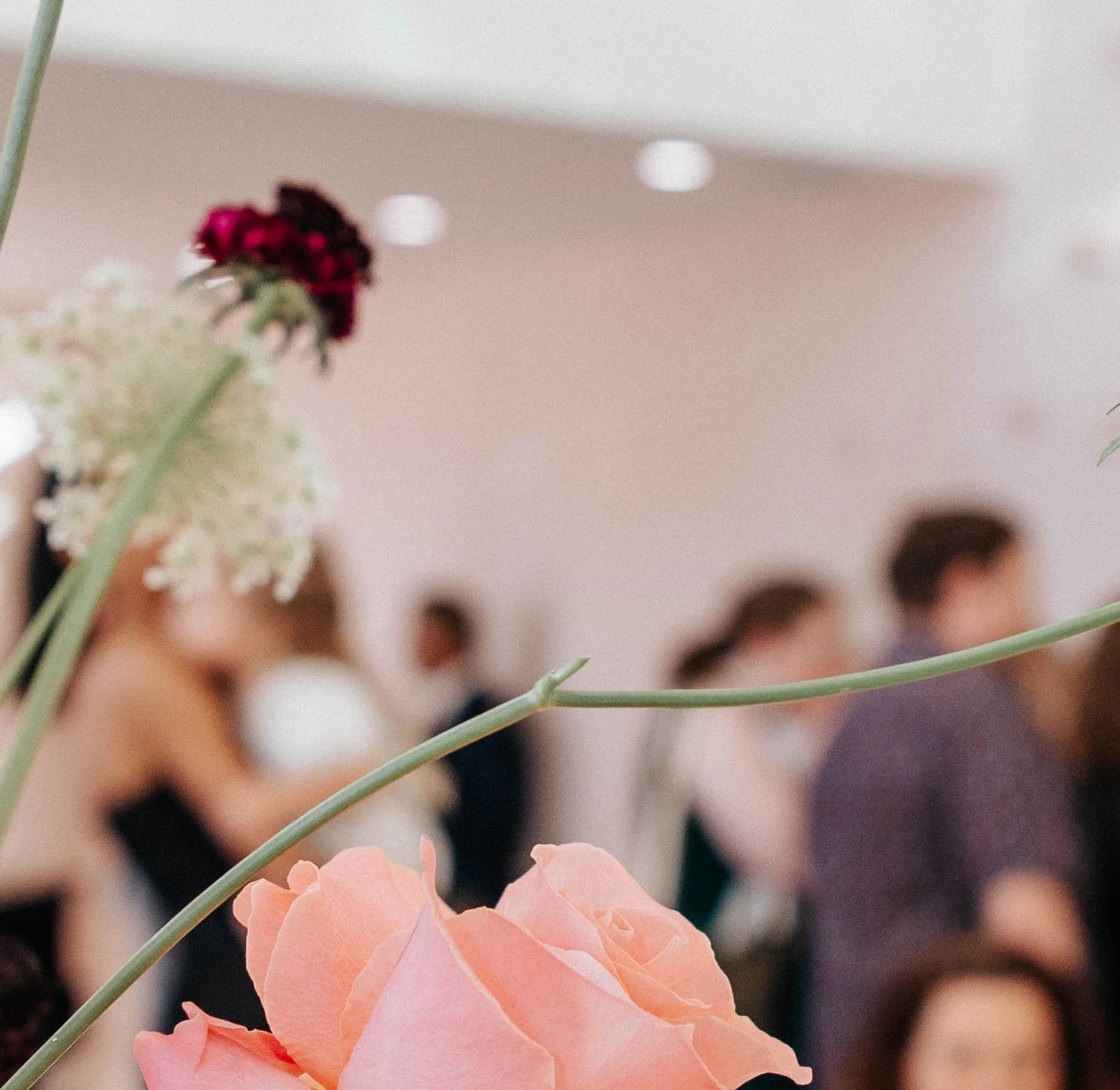 Guests toasting at a festive dining table with floral backdrop