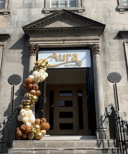 Entrance of Aura Buffet with decorative balloons and elegant architecture.