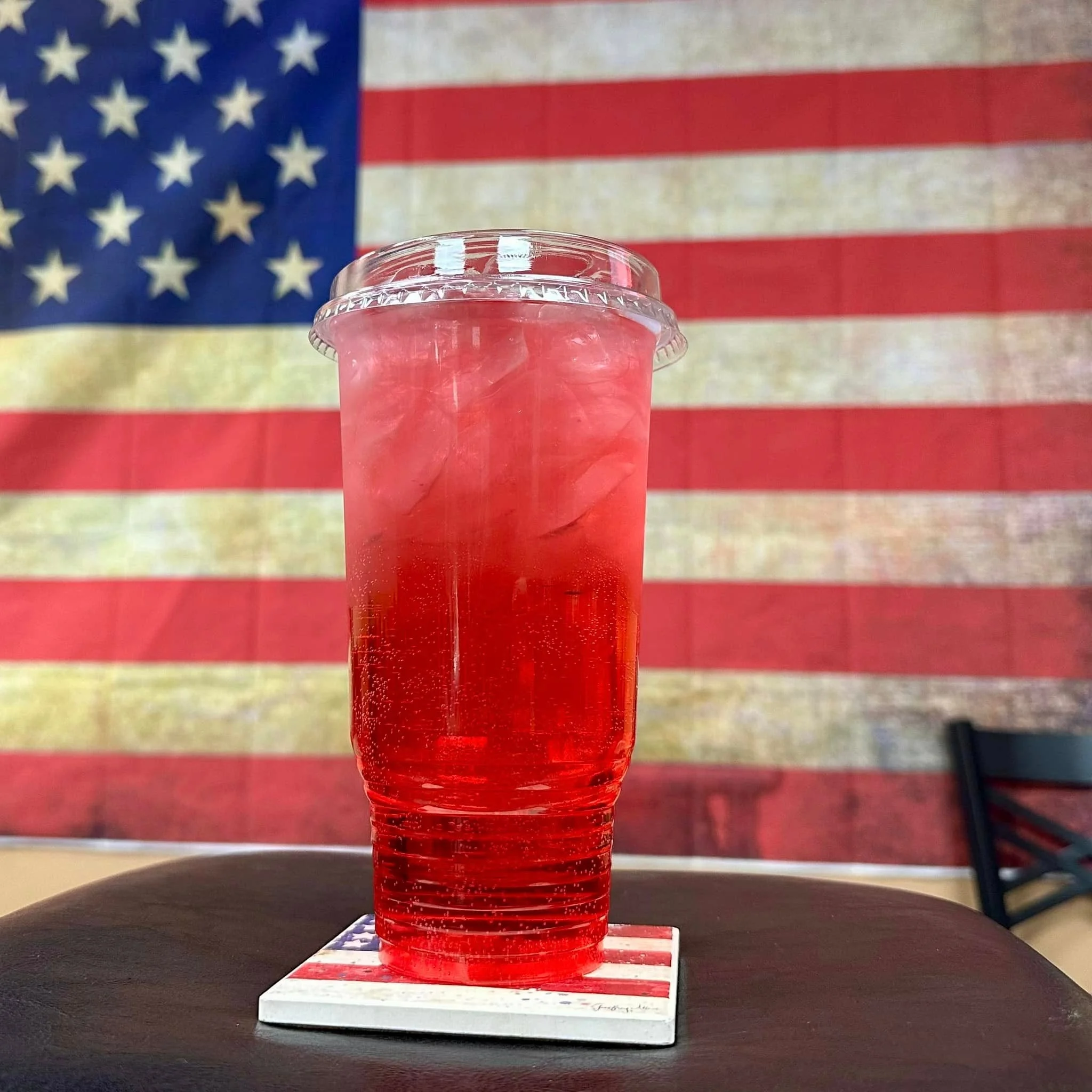 Refreshing red beverage in front of an American flag backdrop