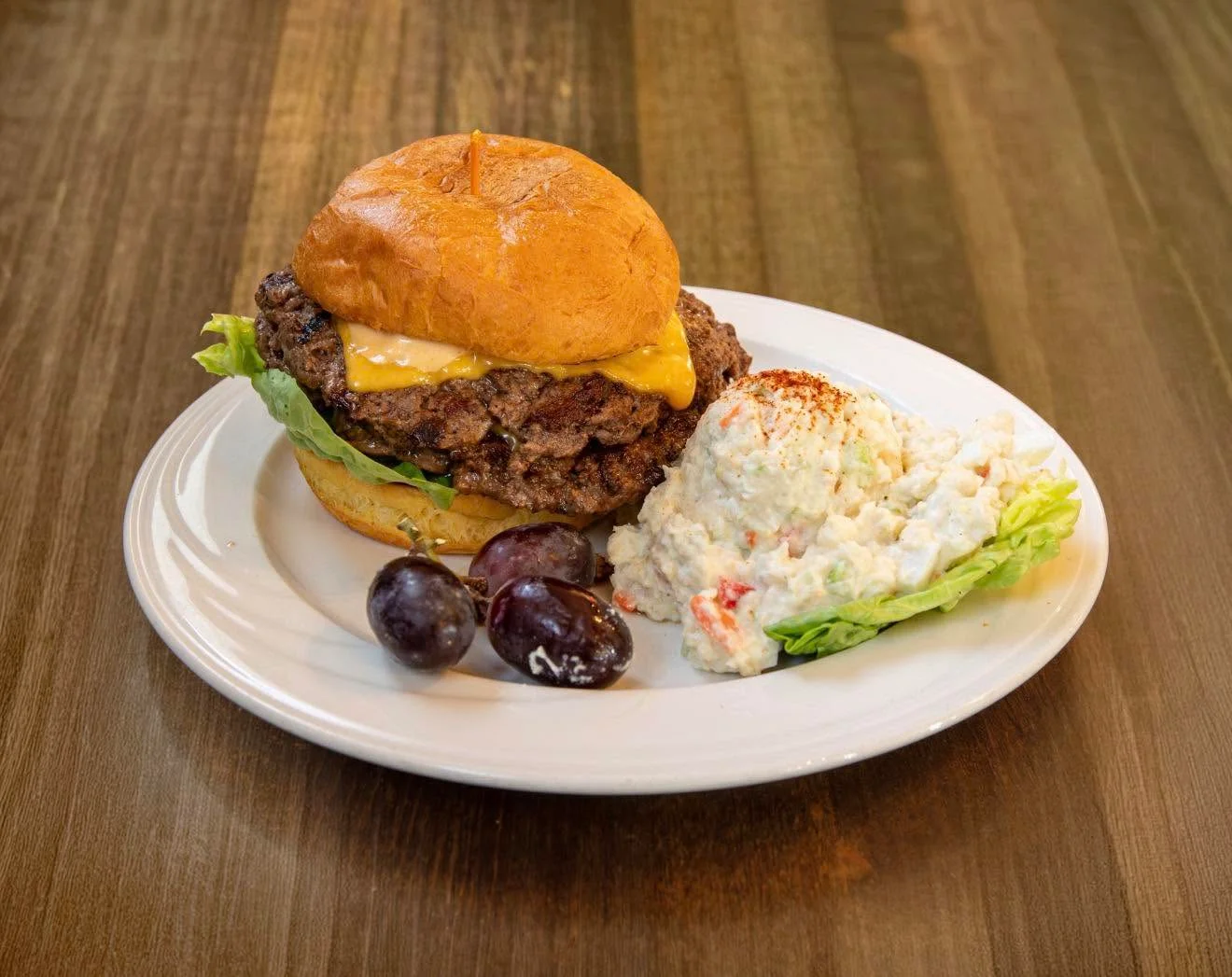 Juicy cheeseburger with lettuce and side salad
