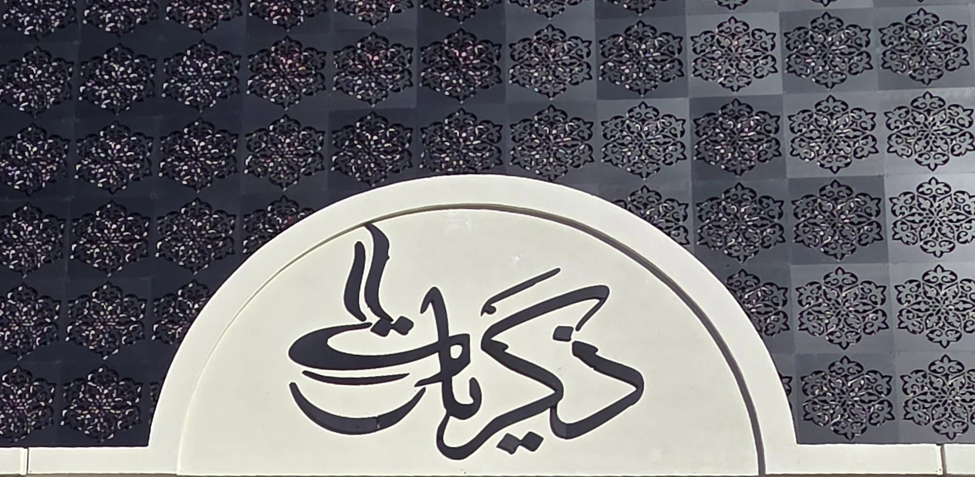 Elegant restaurant sign with intricate Arabic calligraphy