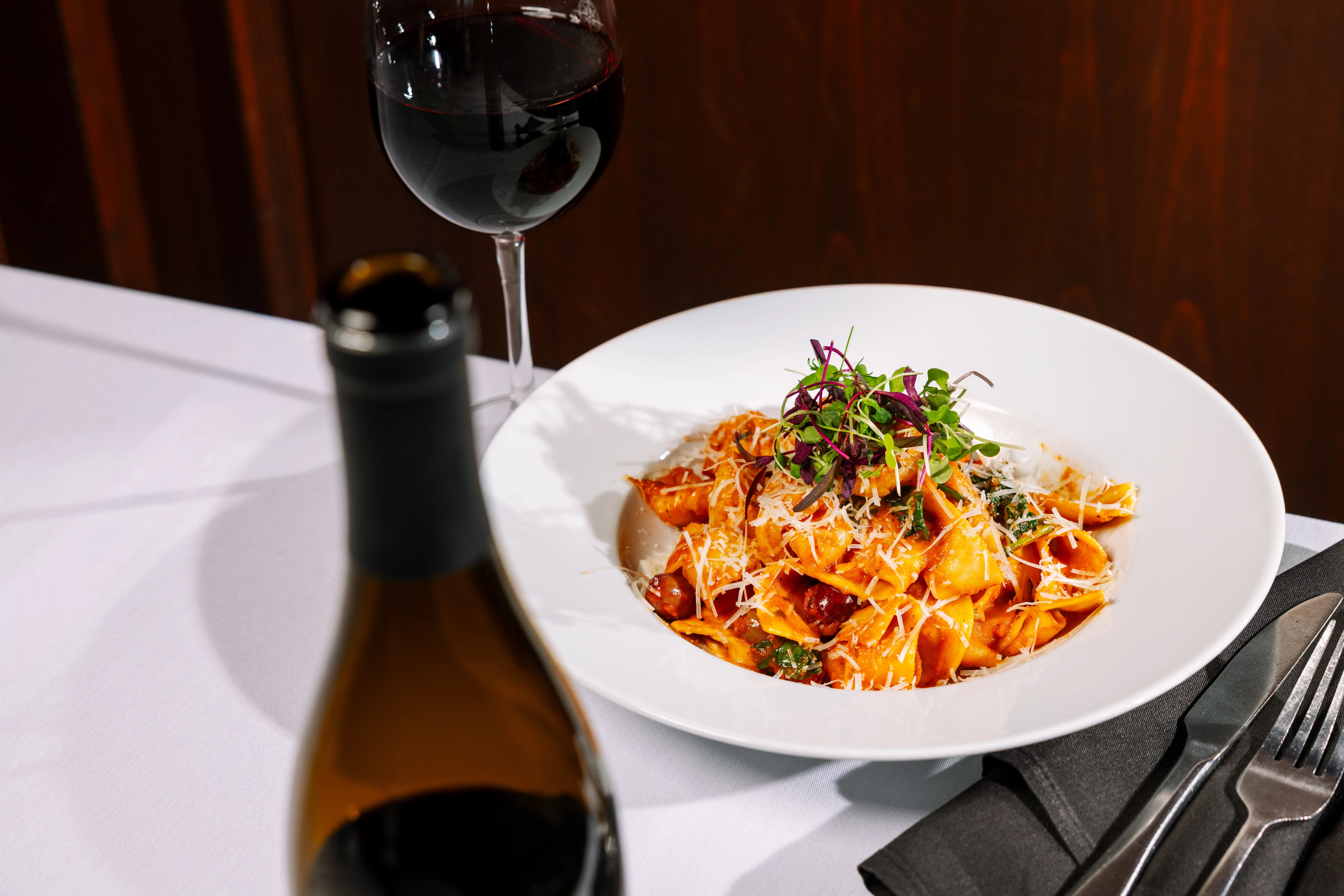 Plate of Italian tortellini with red sauce and herbs