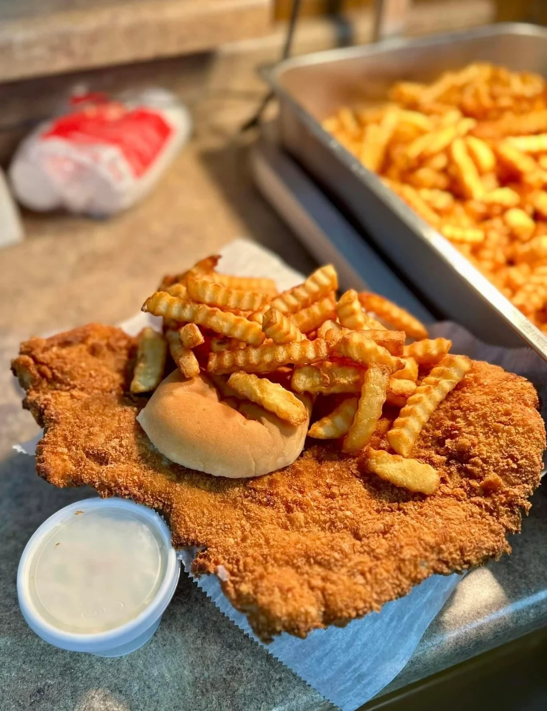 Crispy chicken fried steak with fries and a bun