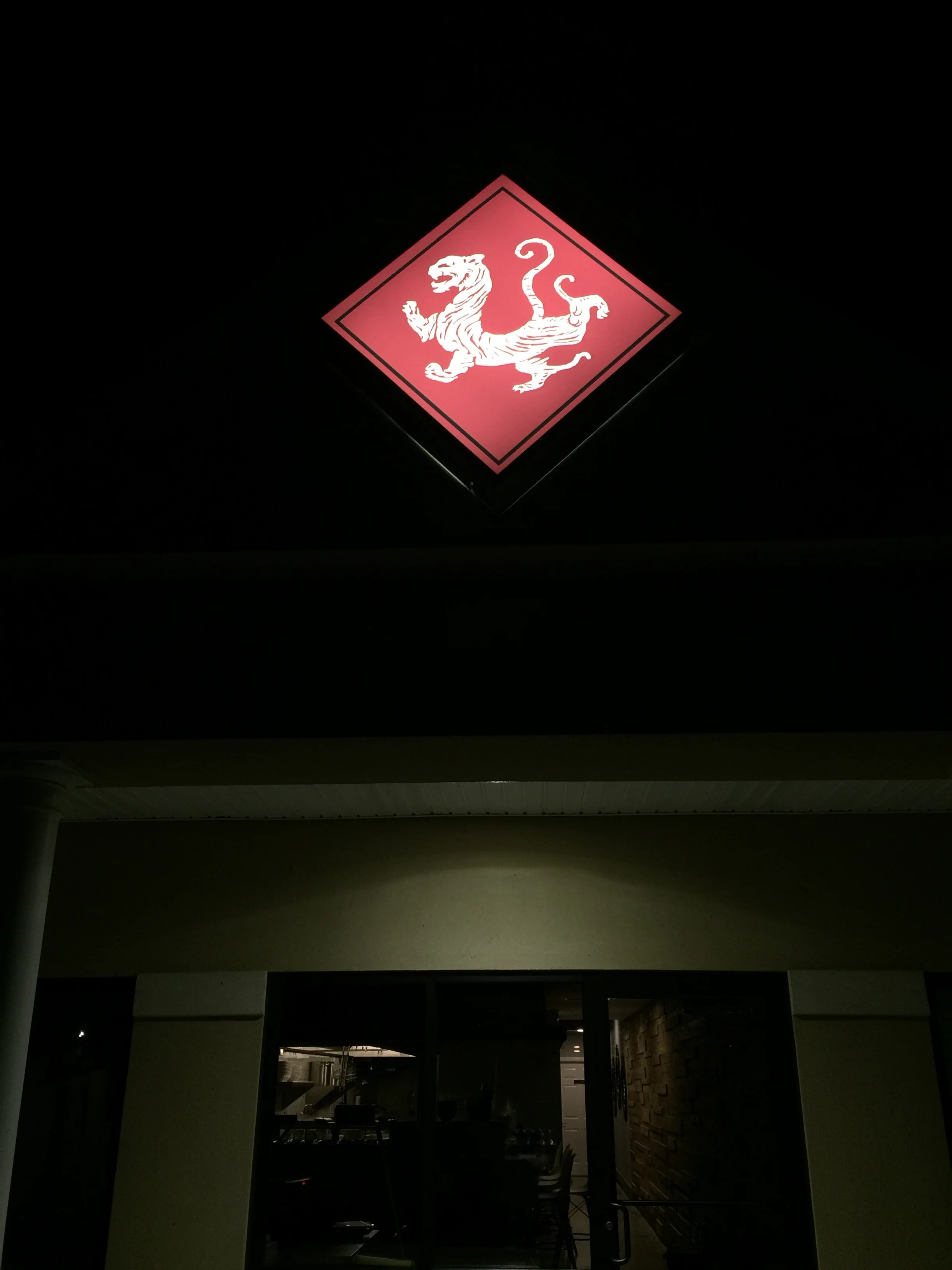 Illuminated restaurant sign featuring a tiger emblem