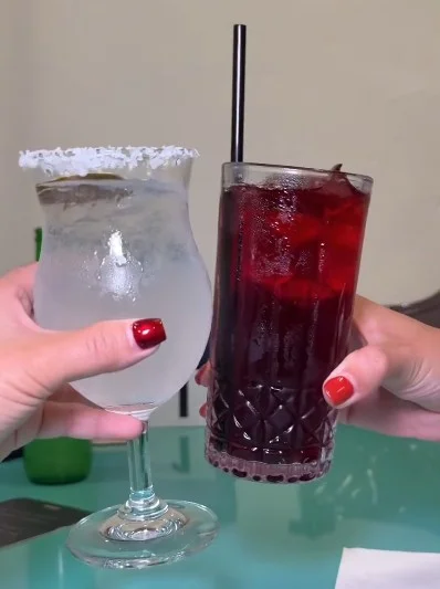Two colorful cocktails clinking in celebration