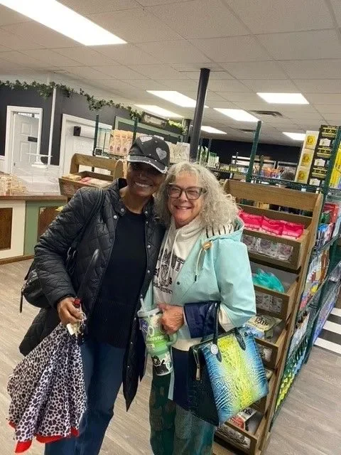 Two women smiling in a cozy store interior