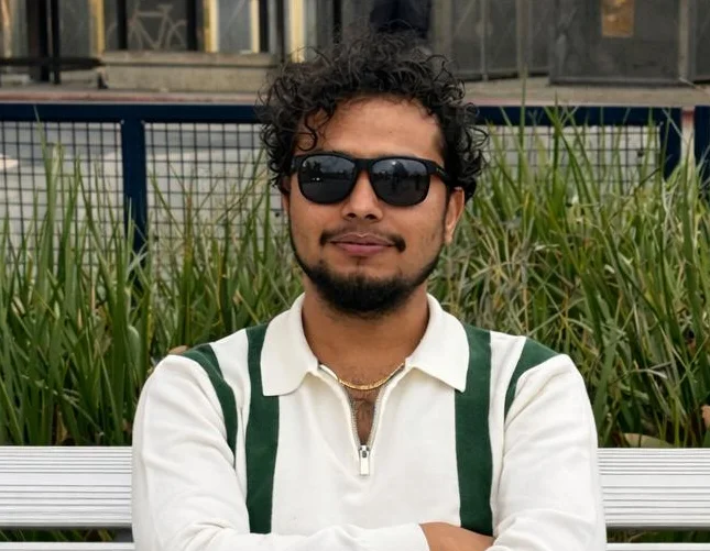 Casual outdoor portrait of a man sitting on a bench