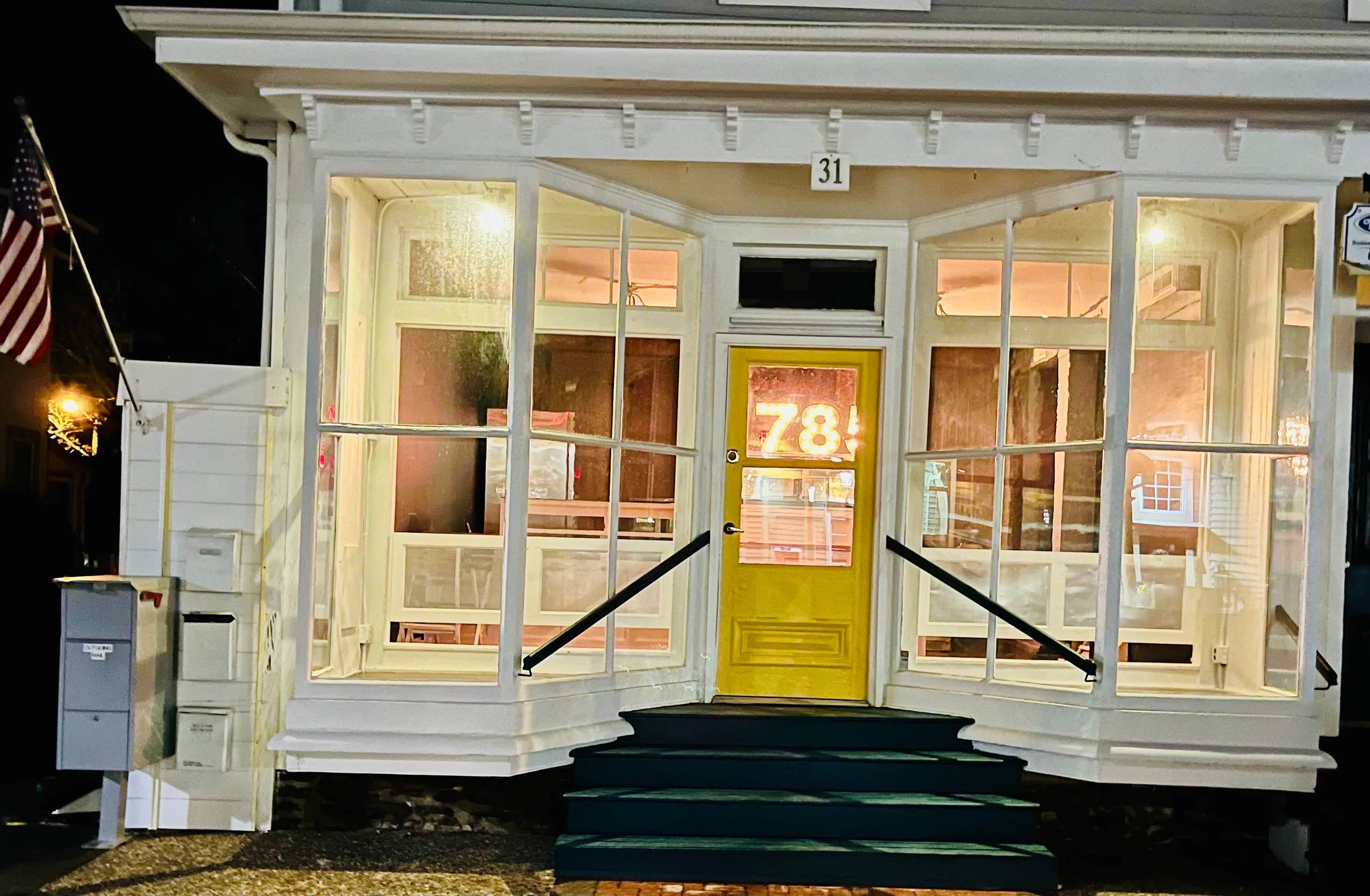 Charming restaurant entrance with yellow door and large windows