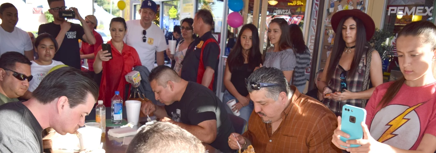 Crowd enjoying a food challenge at a lively restaurant