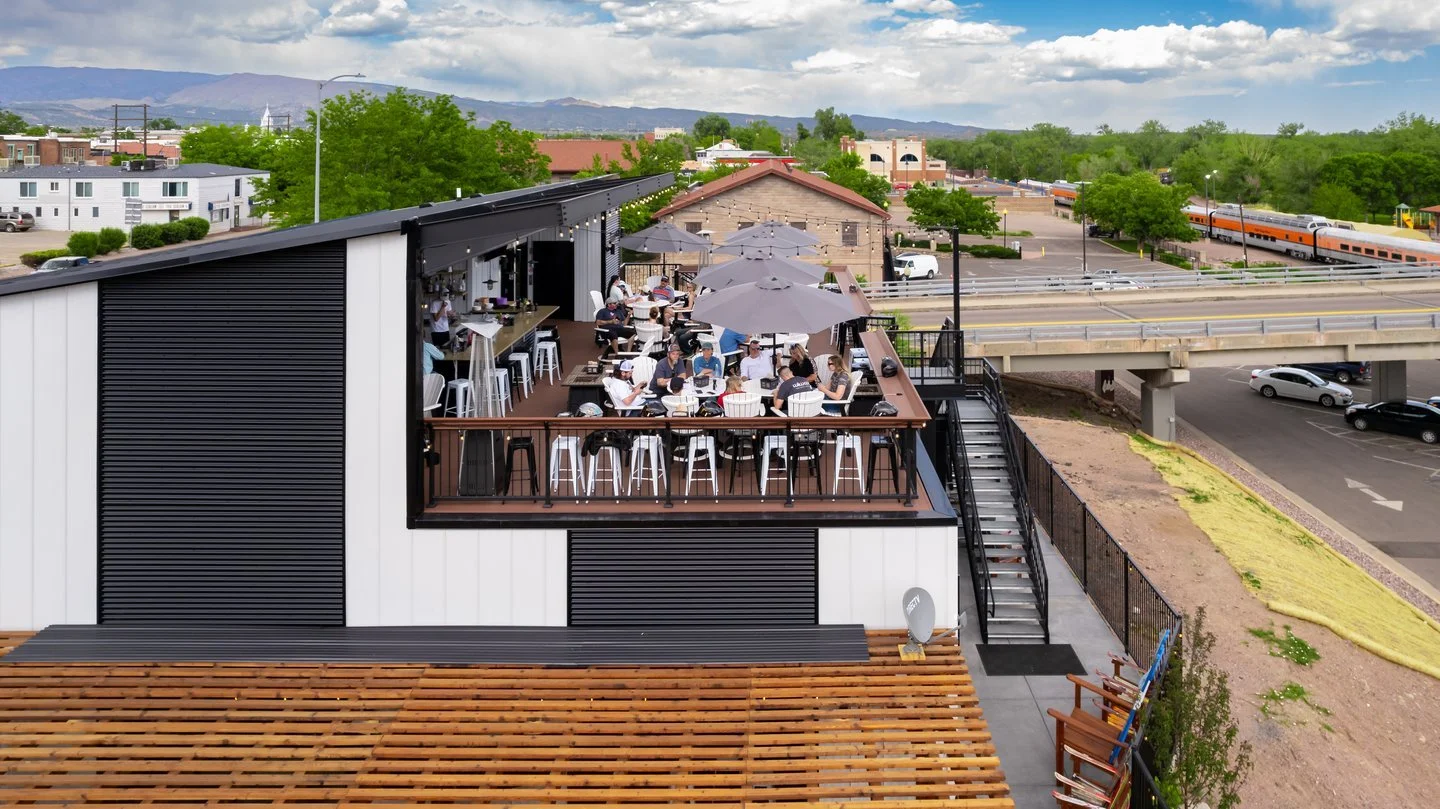 Outdoor dining area with patrons enjoying a meal on a rooftop terrace