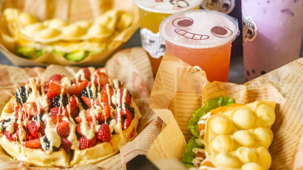 Colorful Hong Kong-style egg waffles with fresh fruit and drinks