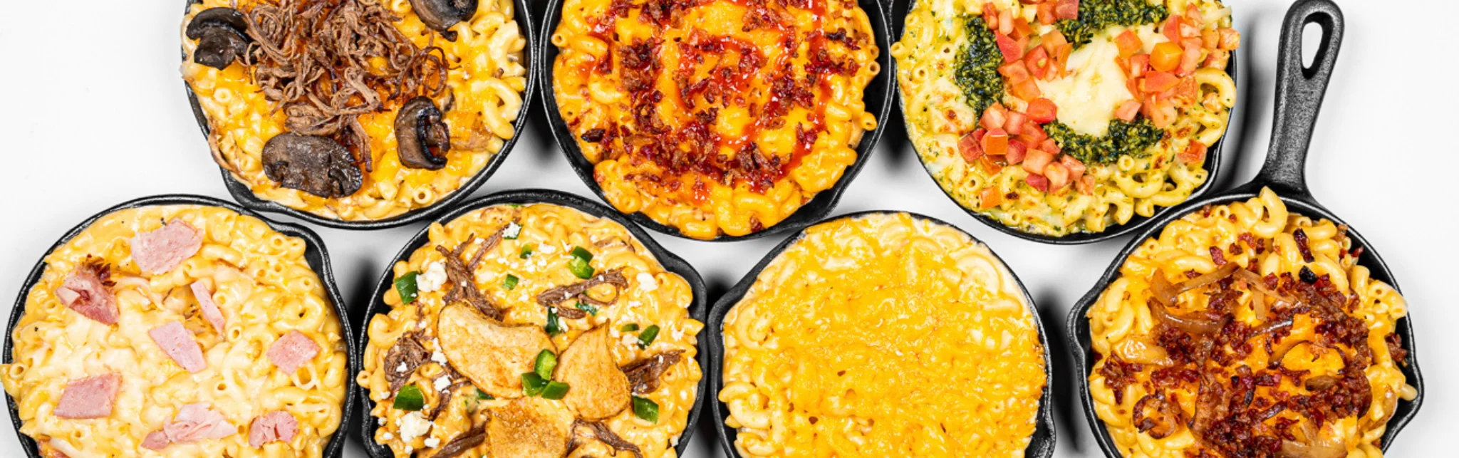 Variety of gourmet mac and cheese in cast iron skillets