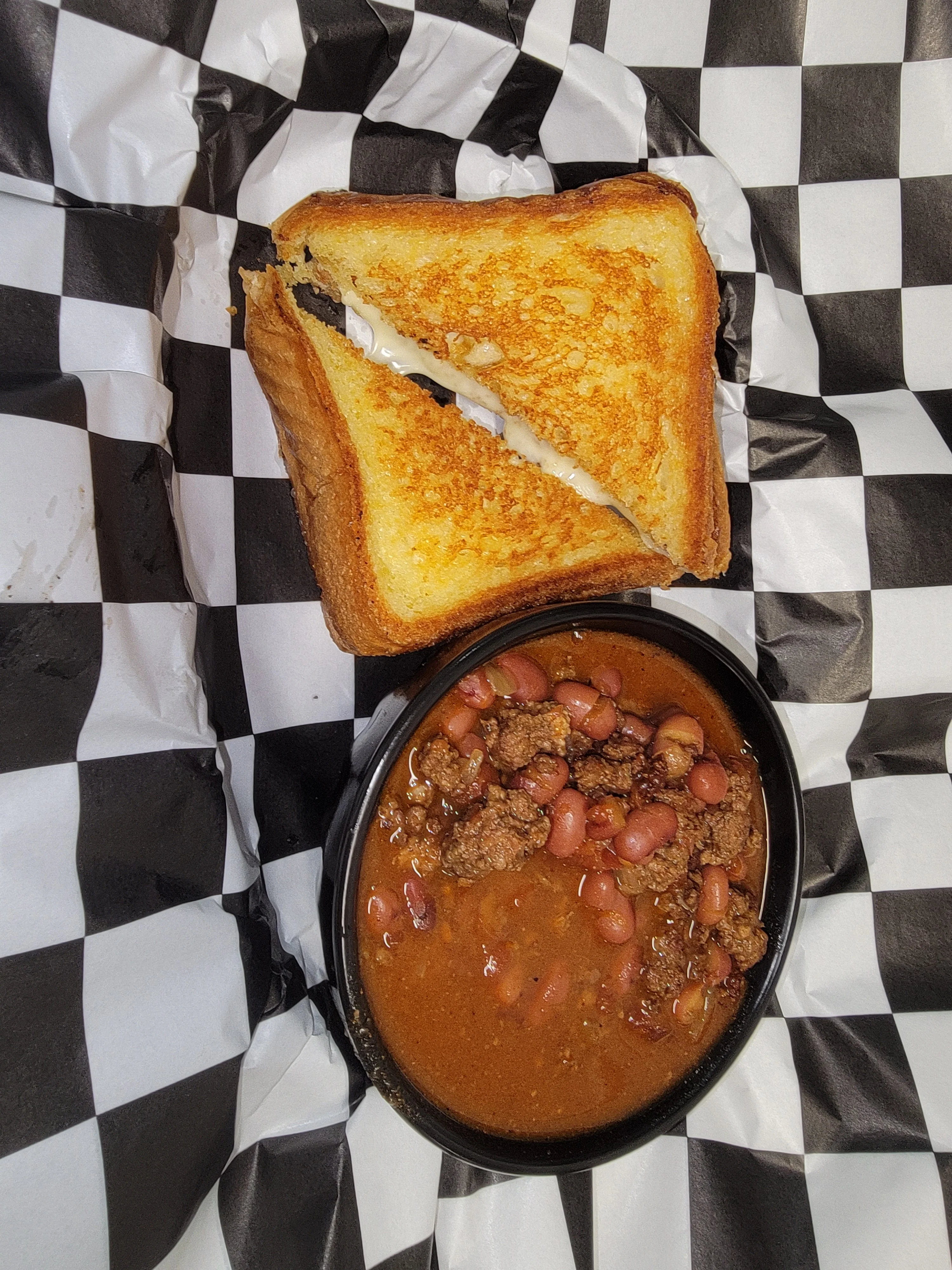 Bowl of chili with cornbread sandwich