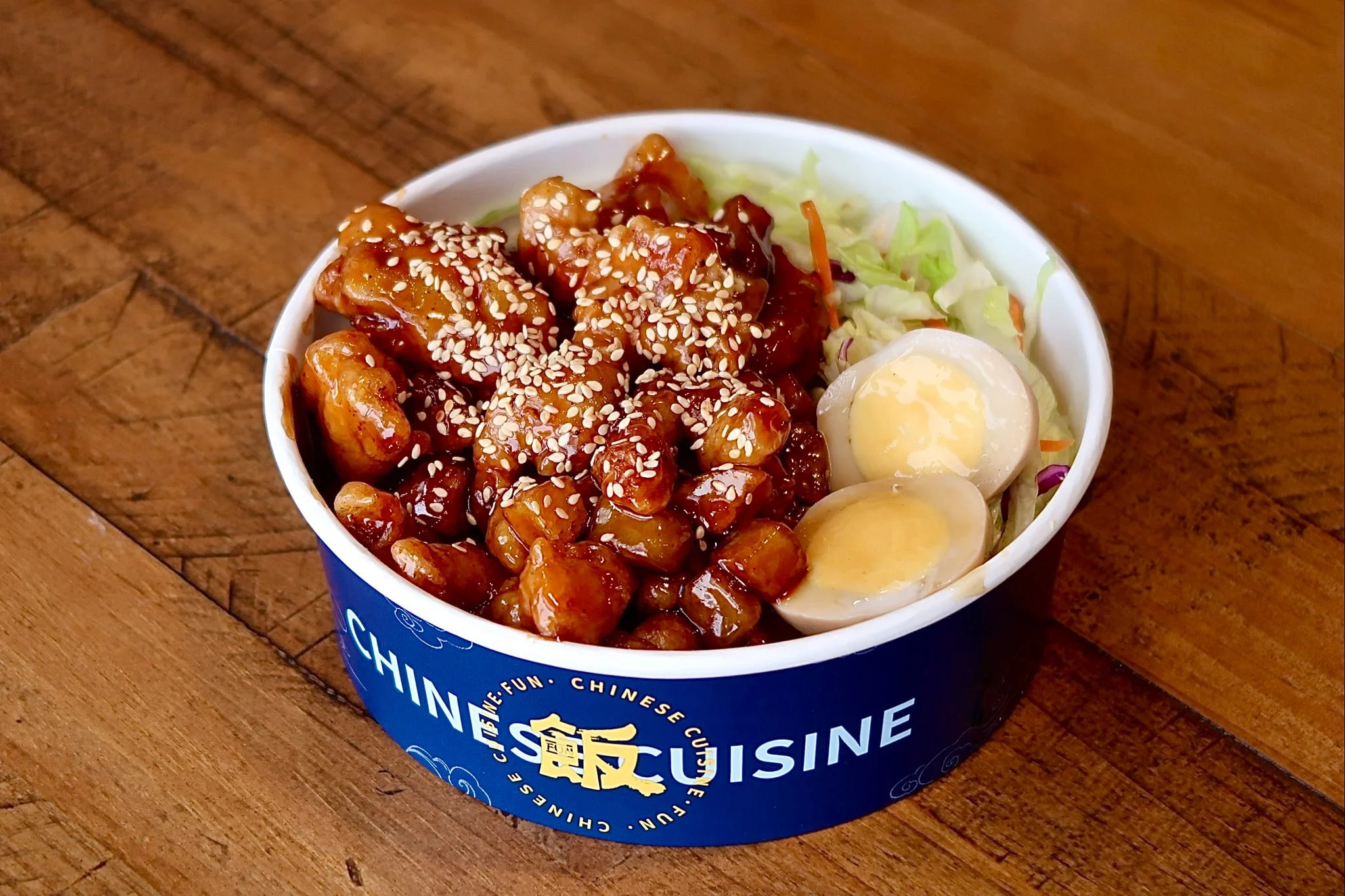 Sesame chicken bowl from Chinese cuisine with fresh salad