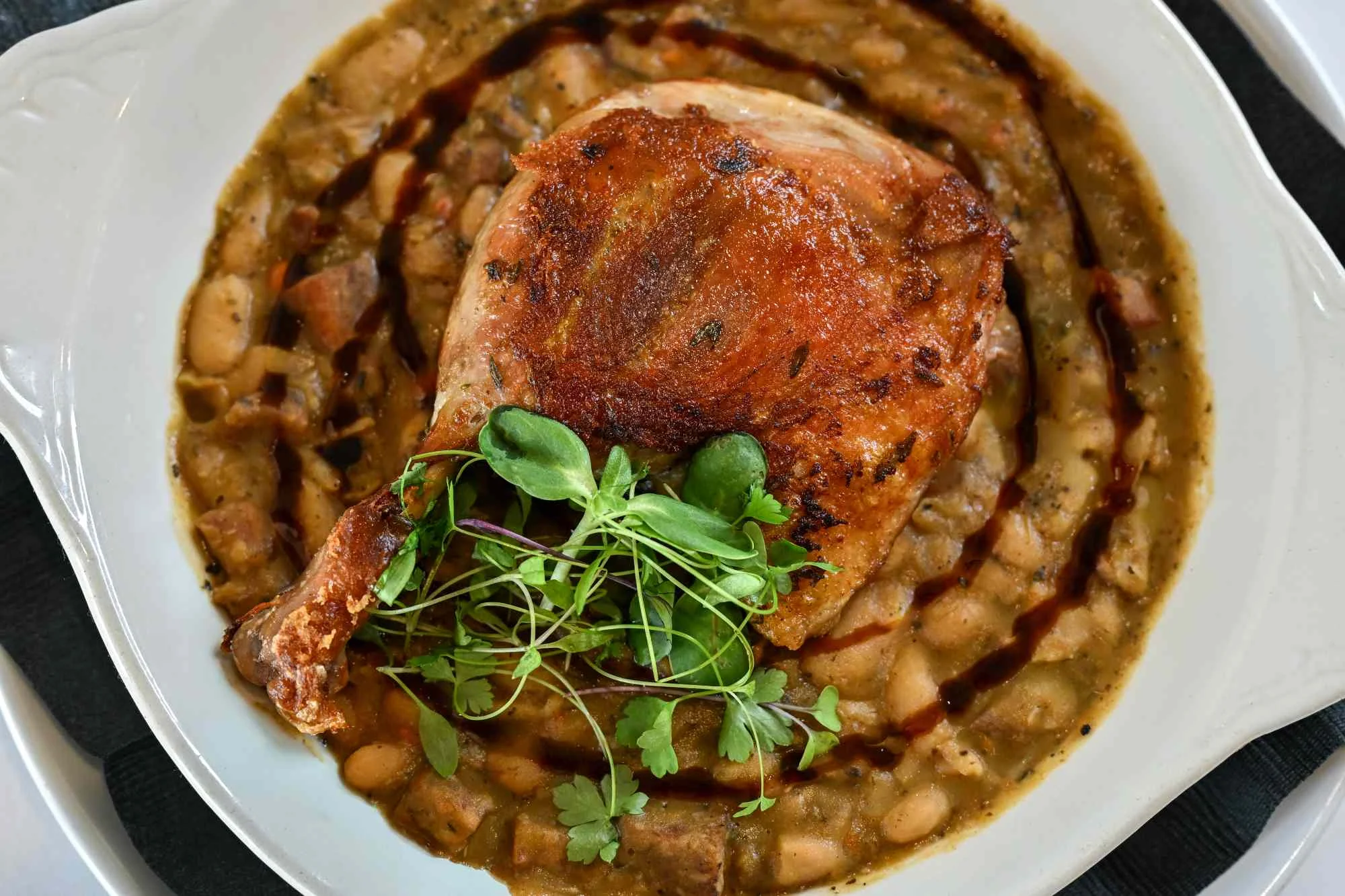 Delicious duck confit served on a plate with garnishes.