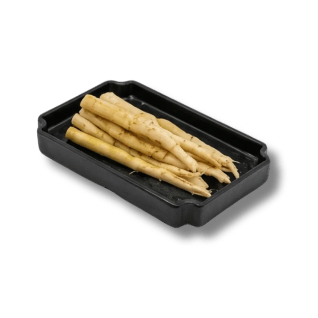 Fresh white asparagus spears in a black tray.
