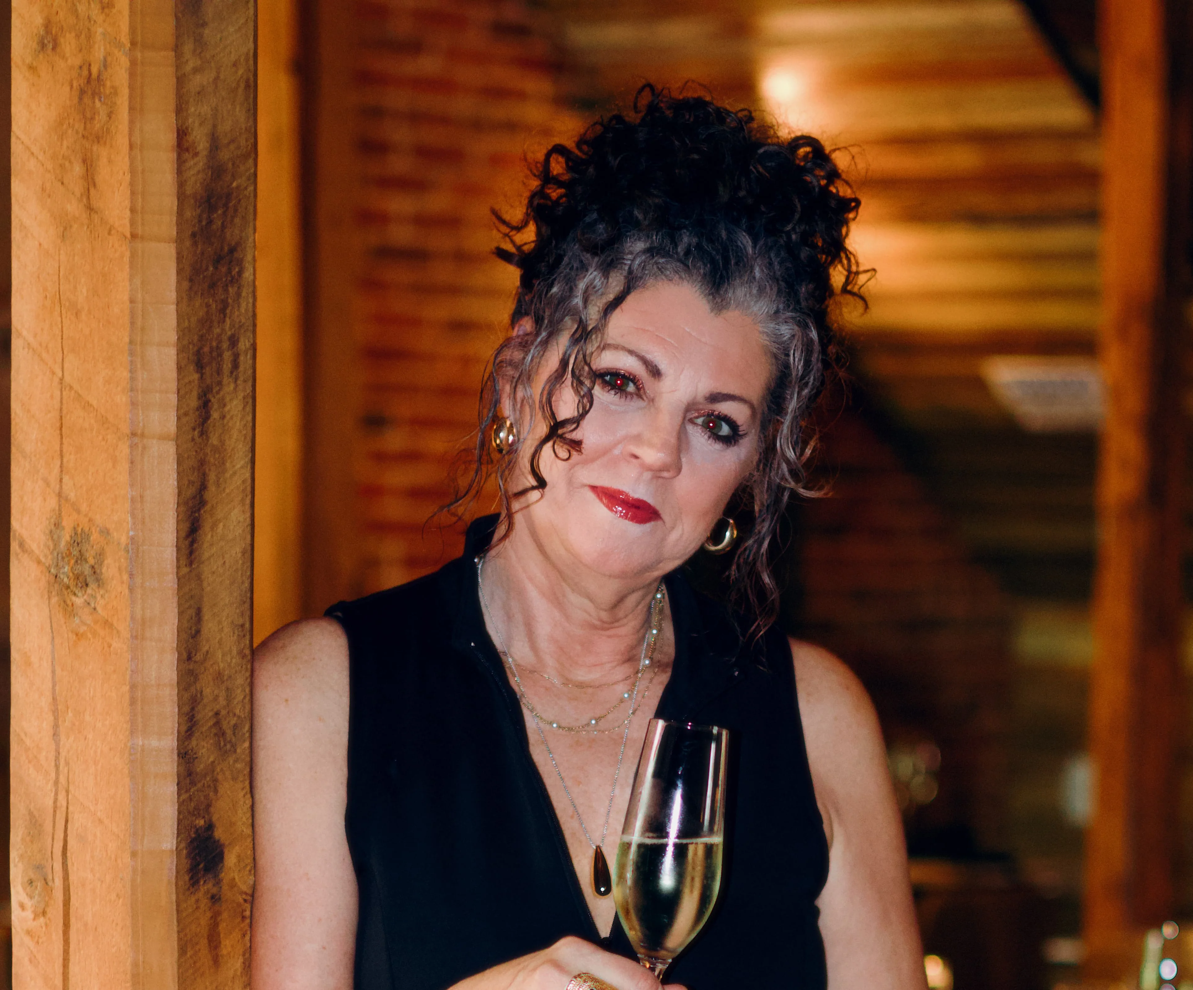 Elegant woman holding a champagne glass in a cozy restaurant setting