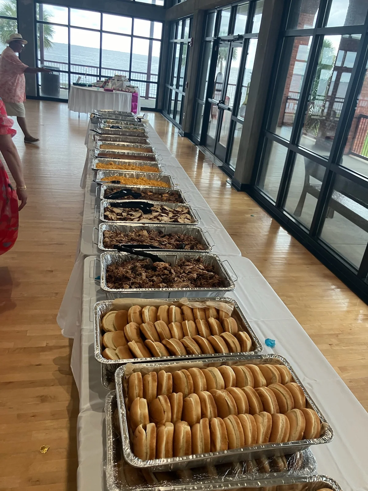 VooDoo BBQ catering buffet table with sandwich buns and assorted BBQ trays prepared for events and gatherings in Pensacola.