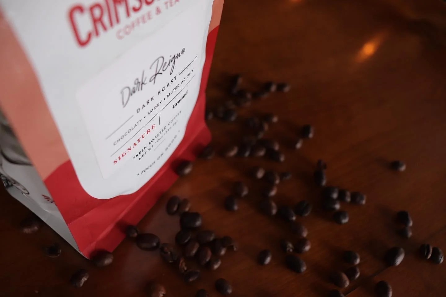 Bag of dark roast coffee on wooden table