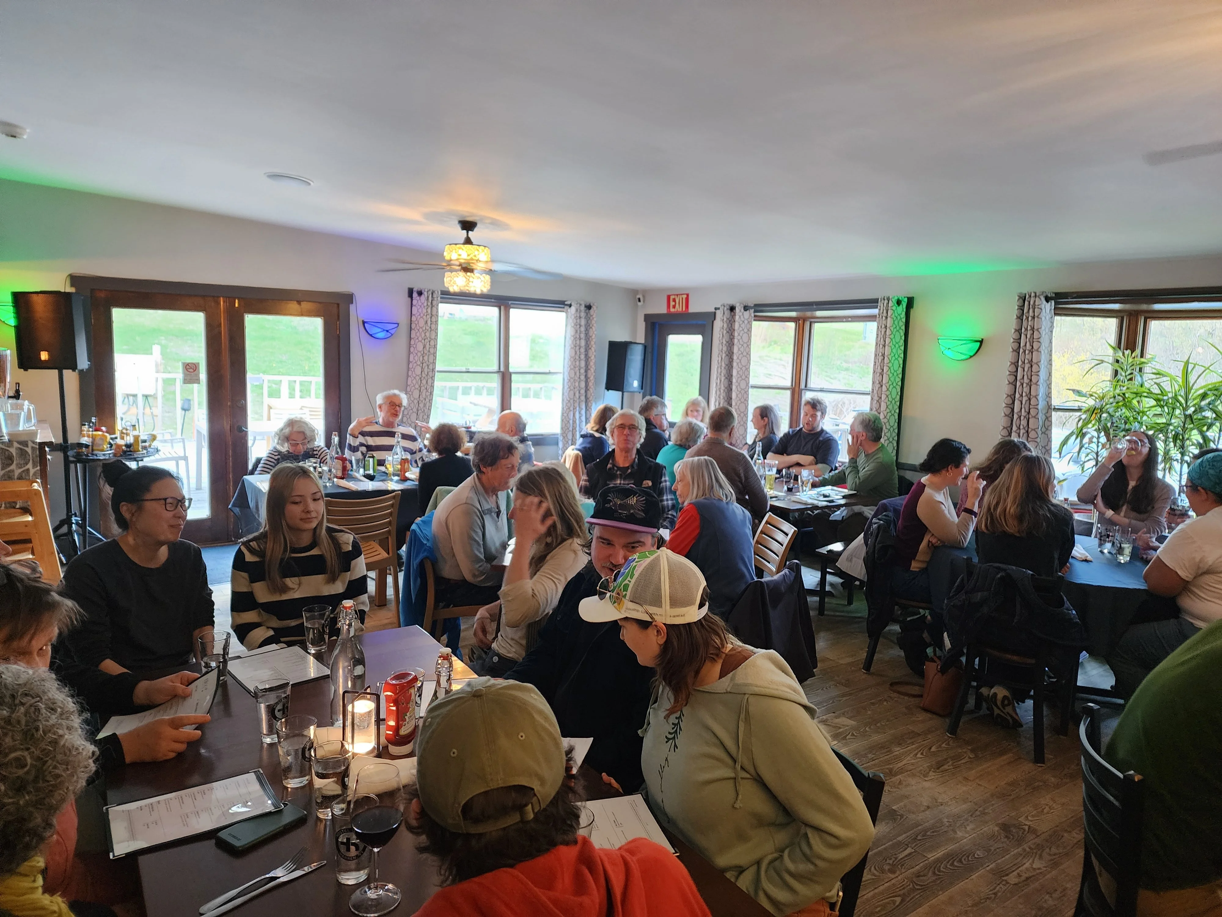 Busy restaurant dining room filled with guests and warm colorful lighting