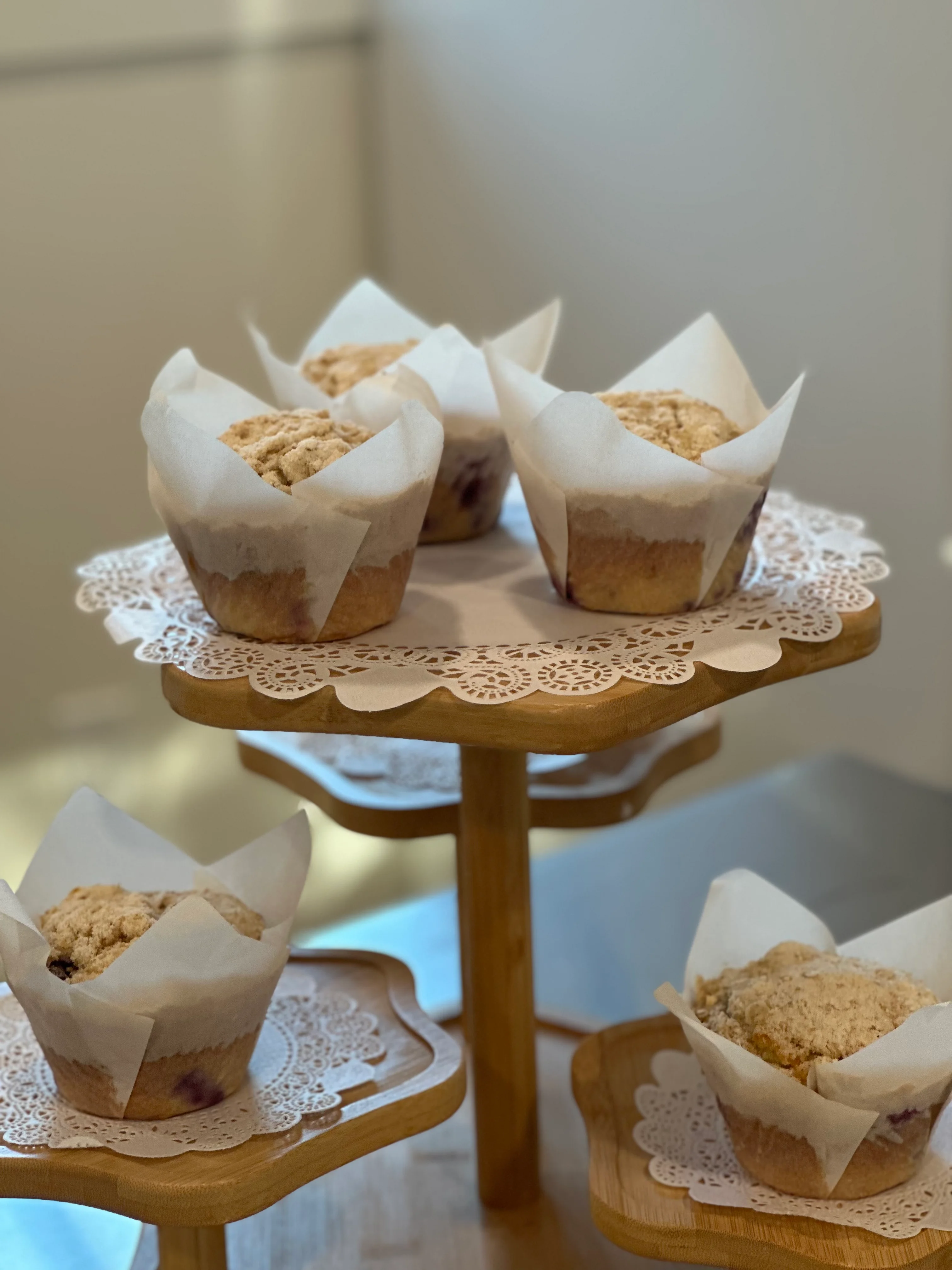 Freshly baked blueberry muffins on a wooden display stand