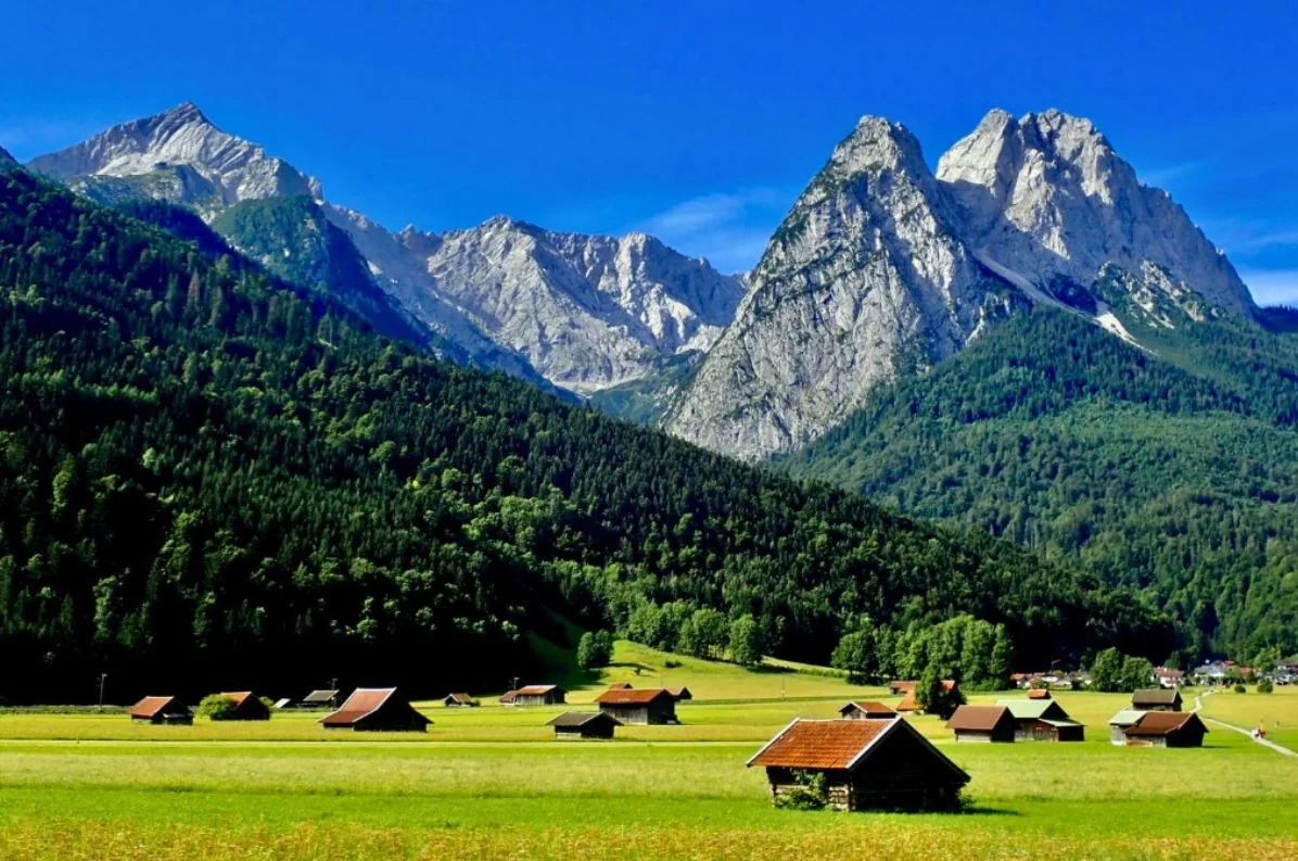 Scenic mountain landscape with lush greenery and wooden cabins