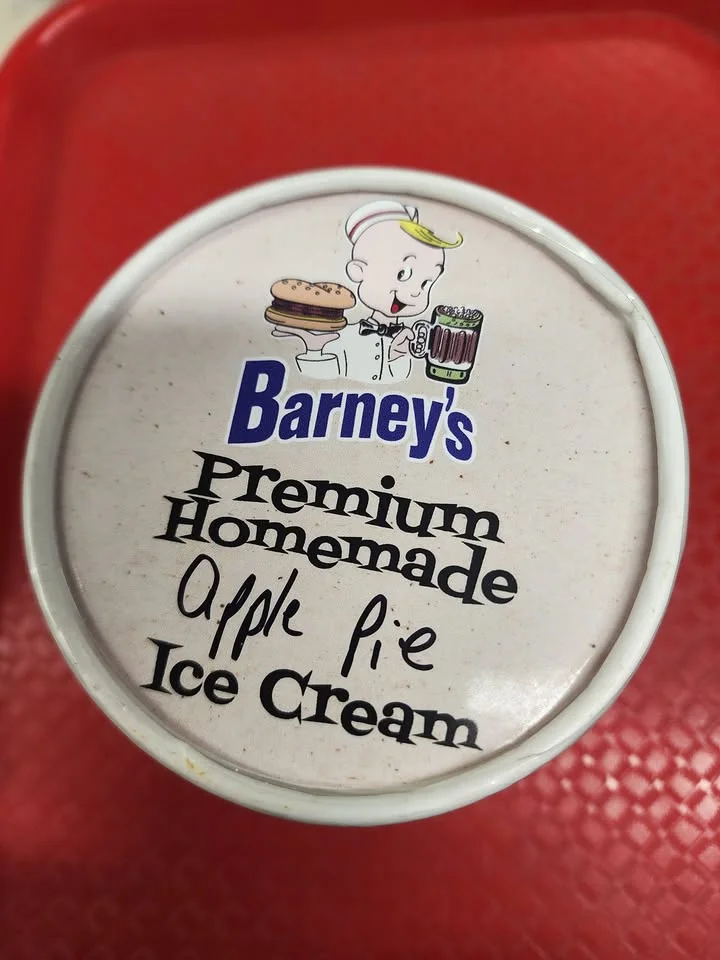 A container of premium homemade apple pie ice cream from Barney's, featuring a character logo on the lid.