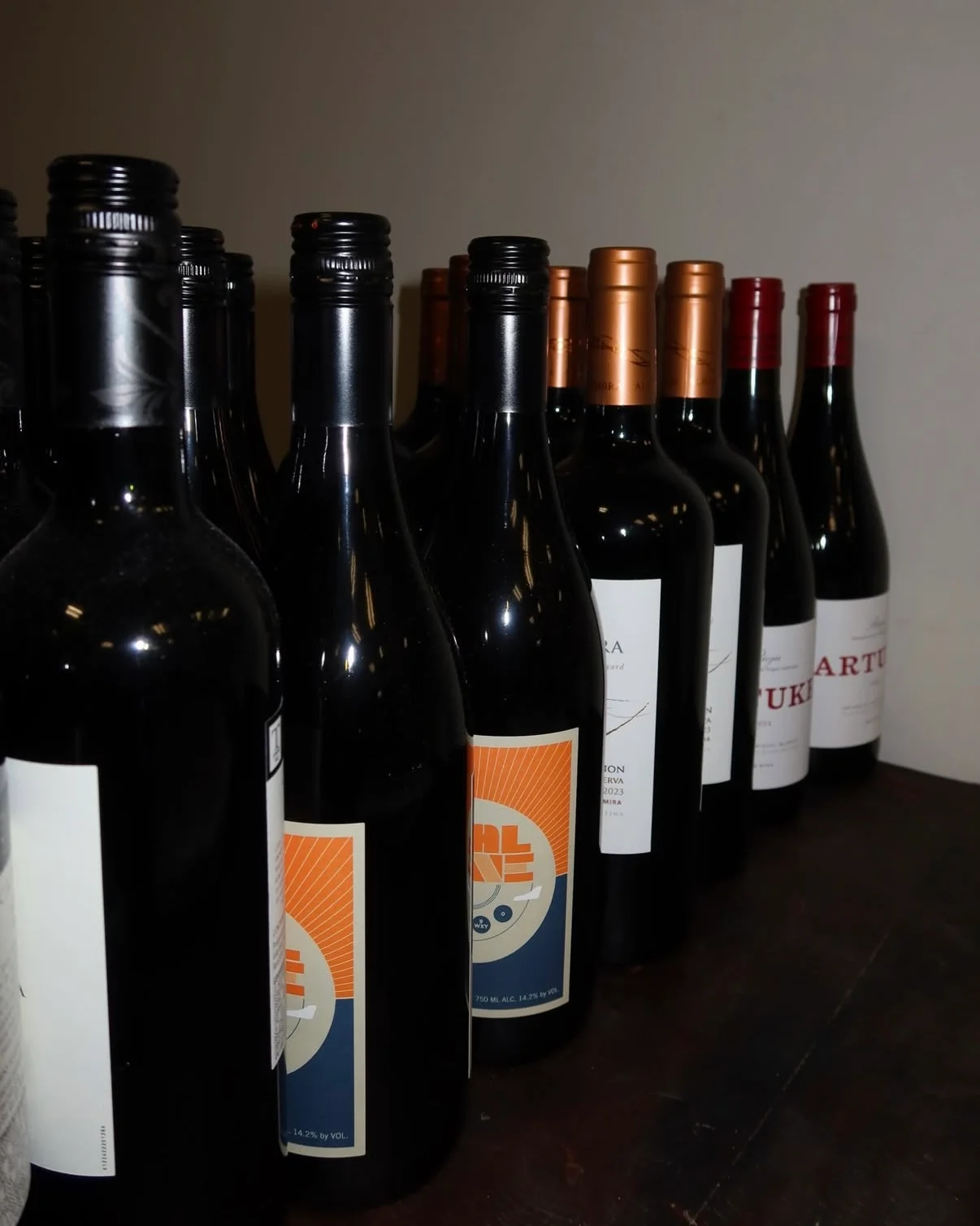 Selection of red wine bottles arranged on a wooden table